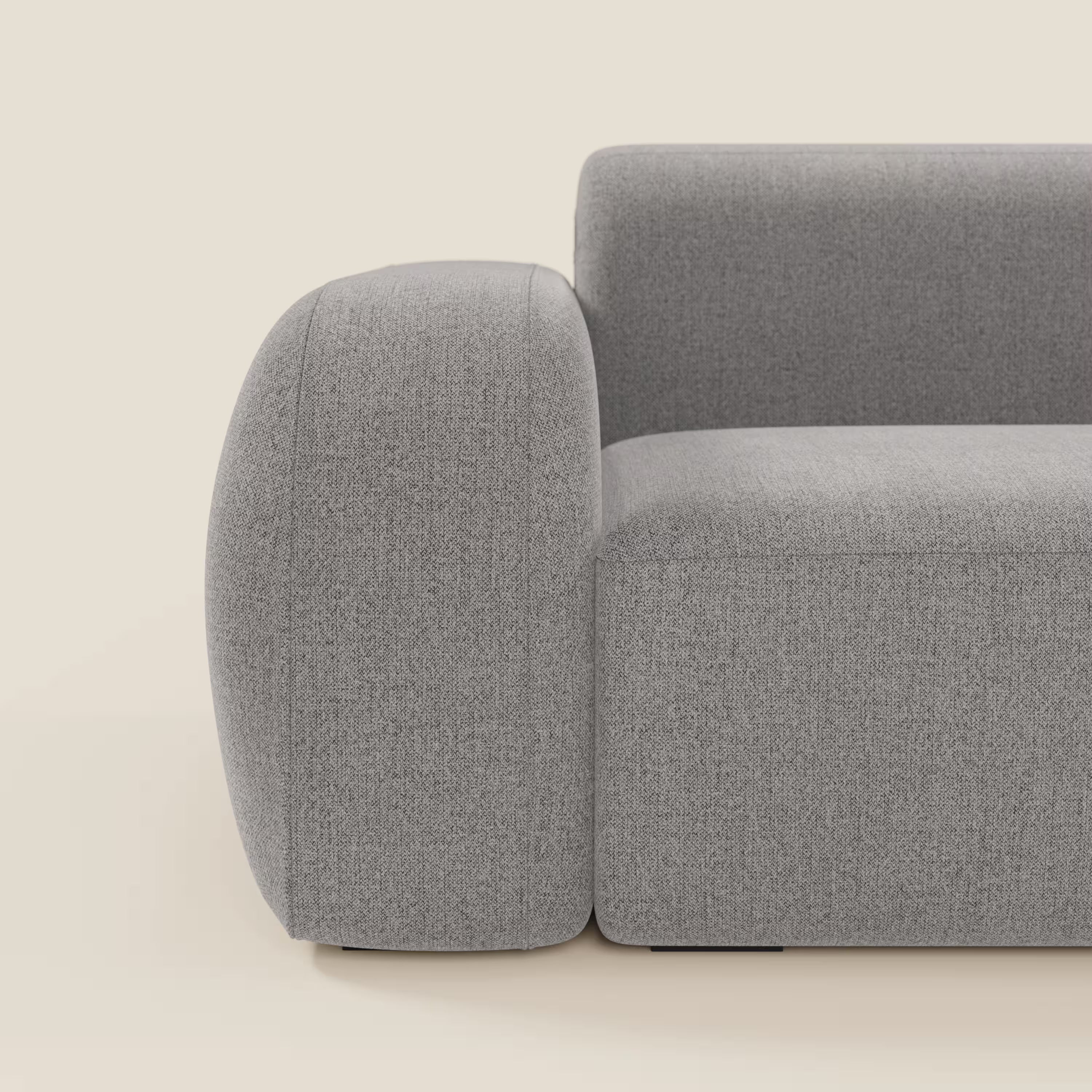 Il BonBon Divano componibile - Composizione Spaccamattone di Divani.Store è presentato di lato in tessuto antimacchia T23 grigio, con braccioli arrotondati e seduta squadrata a basso profilo, su sfondo beige. È visibile solo un'estremità.