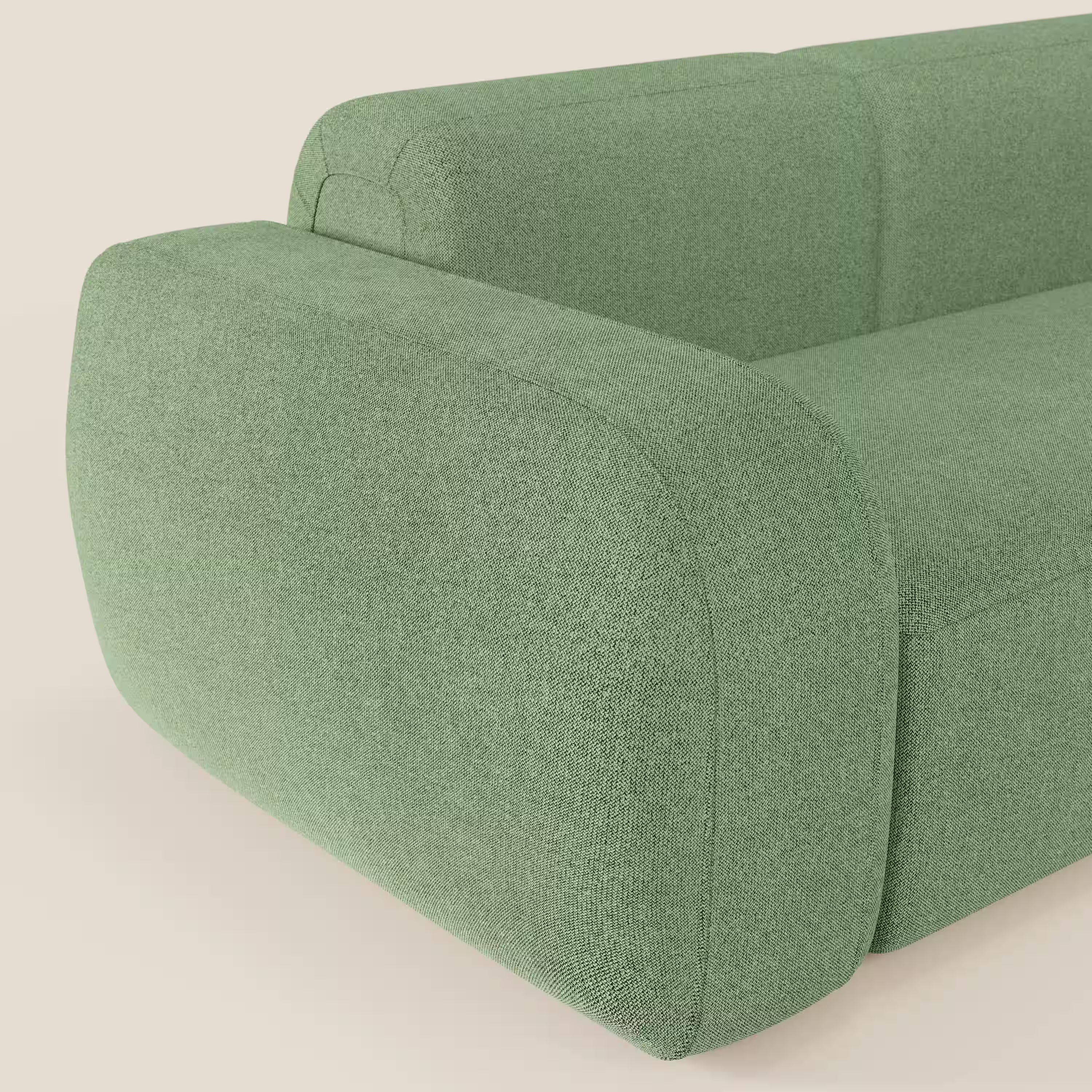 Primo piano del BonBon Divano componibile - Composizione Spaccamattone di Divani.Store, presentato in tessuto smacchiabile T23 menta. L'immagine mette in evidenza i suoi bordi arrotondati e il suo design unico su uno sfondo beige chiaro.