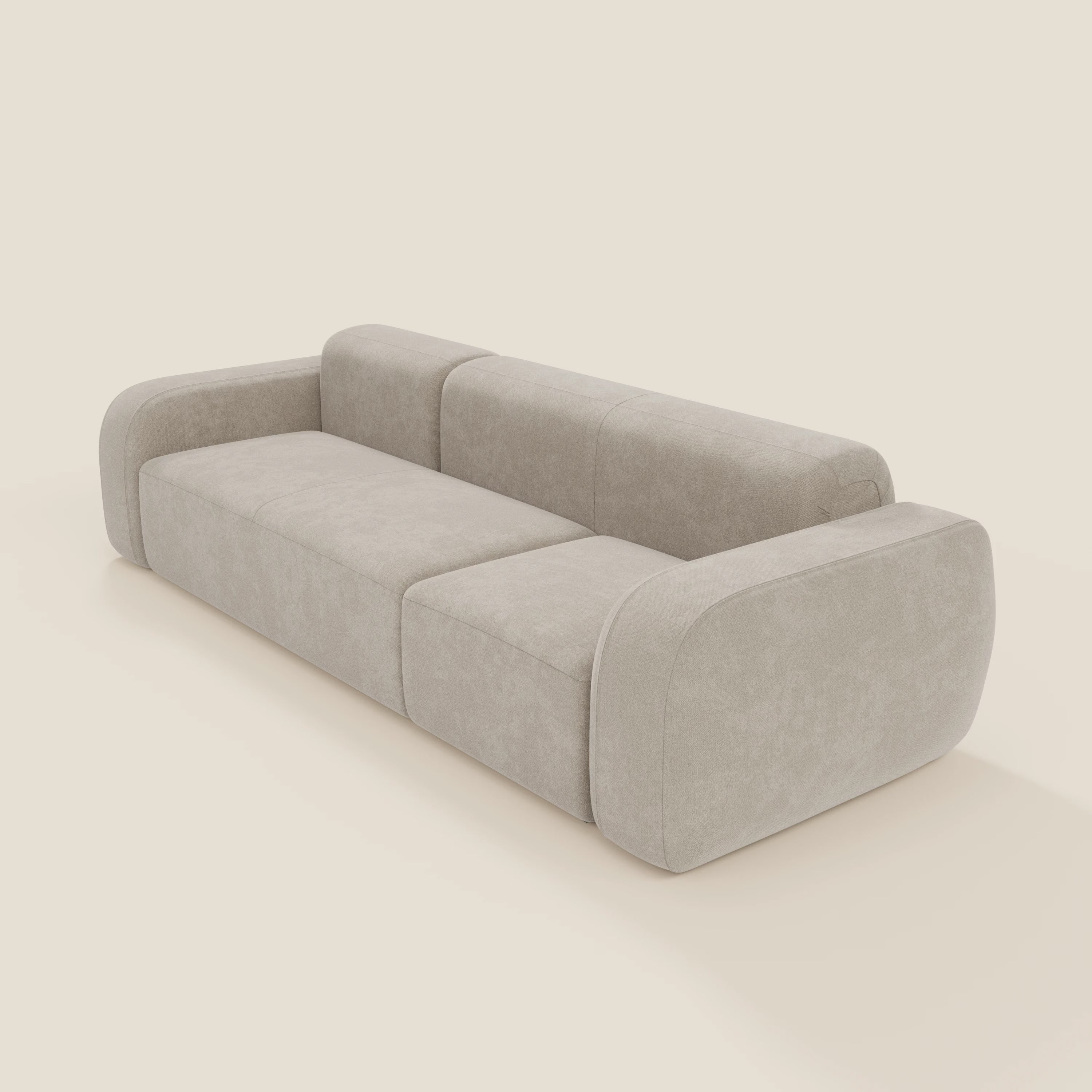 Il BonBon Divano componibile Spaccamattone di Divani.Store è caratterizzato da un design a tre posti con braccioli e bordi arrotondati, rivestito in tessuto panna T23 antimacchia, che offre un'eleganza minimalista su uno sfondo bianco sporco.