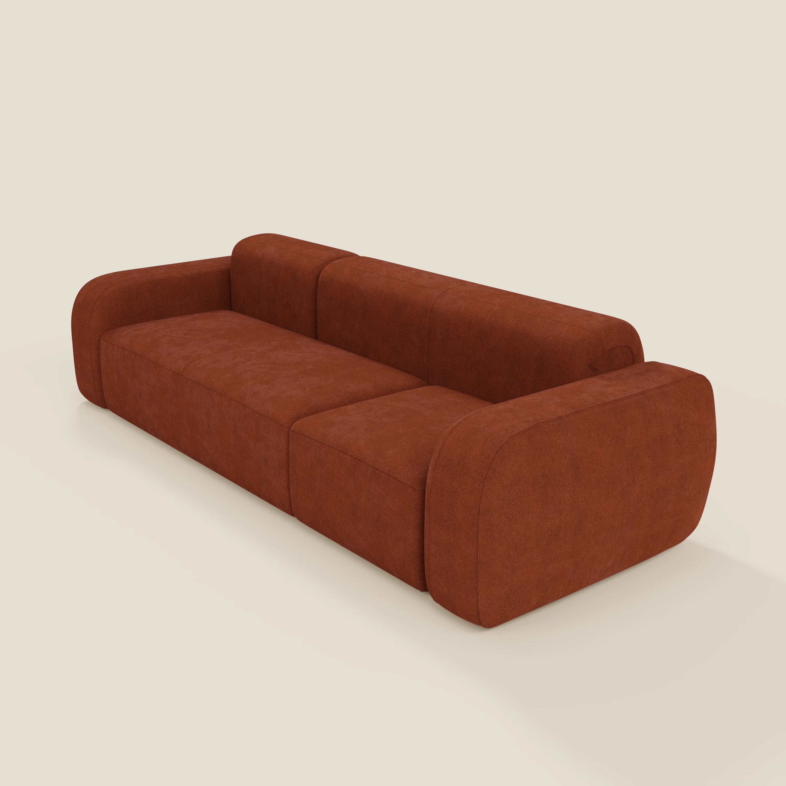 Il divano componibile BonBon - Composizione Spaccamattone di Divani.Store è caratterizzato da tessuto T23 color ruggine e antimacchia, braccioli e schienali spessi e arrotondati, tre ampi cuscini di seduta e un design moderno e minimalista su sfondo chiaro.