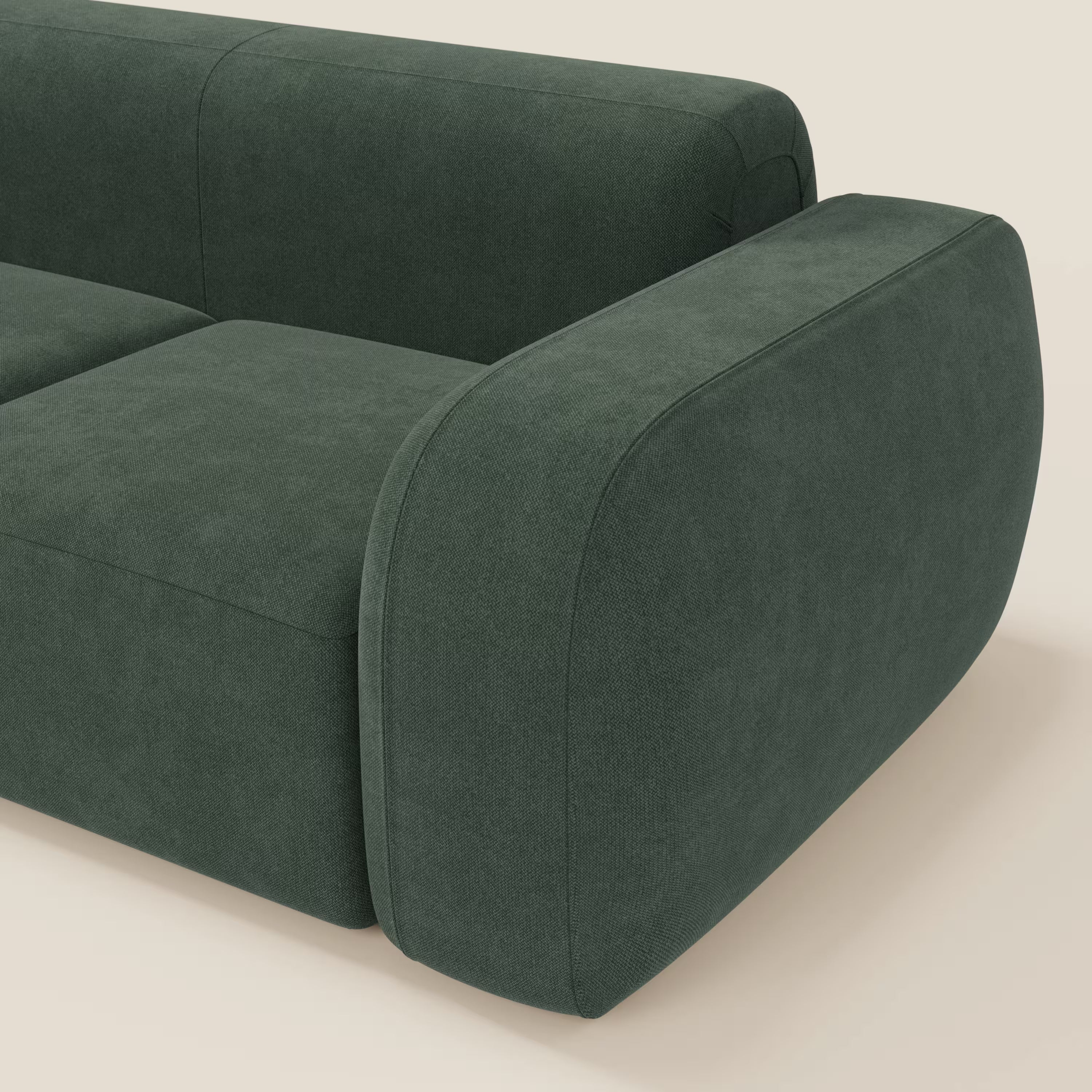 Primo piano del divano componibile BonBon Divano - Composizione Spaccamattone in tessuto smacchiabile T23 verde di Divani.Store, con cuscini e braccioli arrotondati, su sfondo beige chiaro.