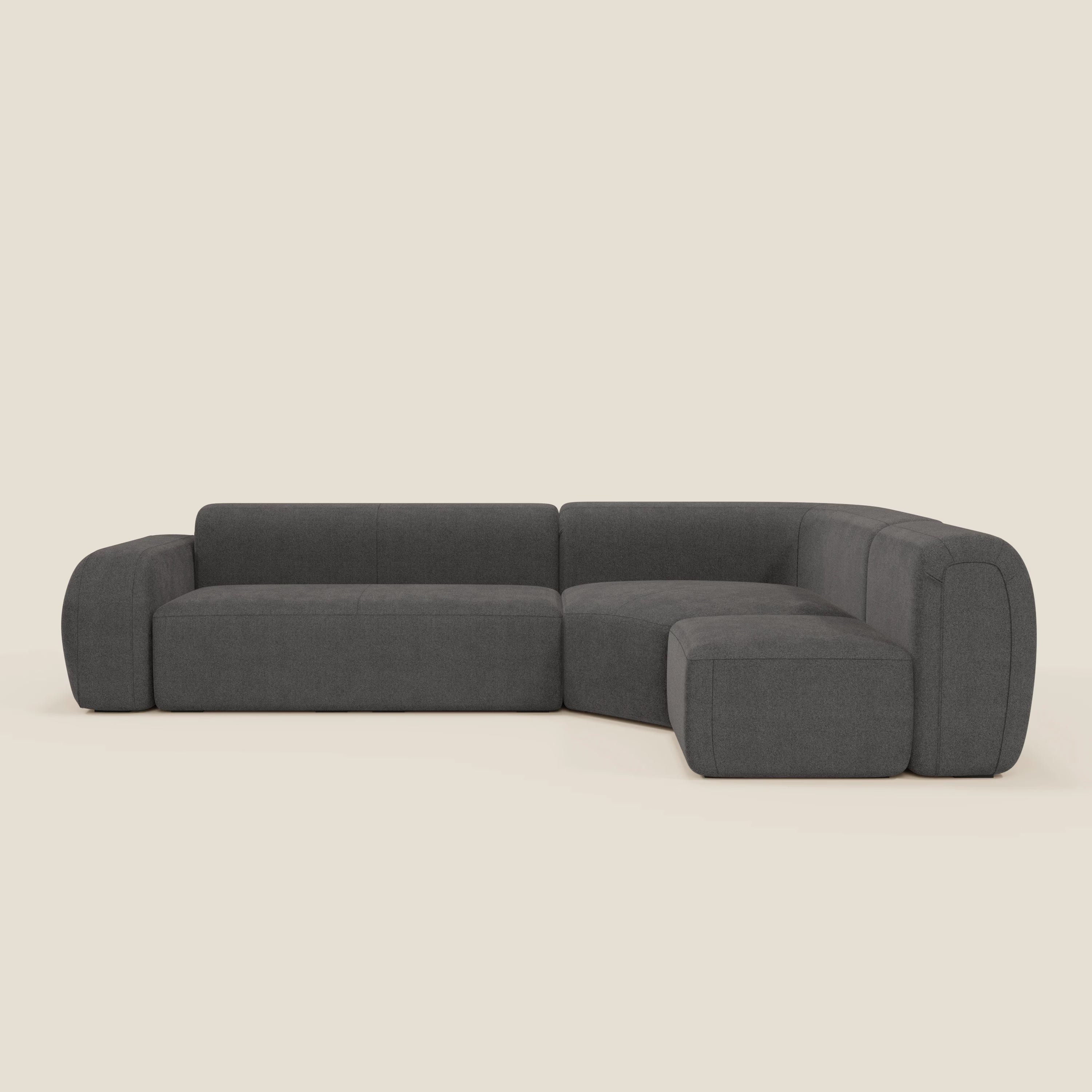 Il divano angolare componibile e modulare BonBon di Divani.Store, in tessuto smacchiabile T23 antracite, è caratterizzato da sedute morbide, bordi arrotondati, schienali bassi e un design minimalista e contemporaneo a forma di L su sfondo neutro.
