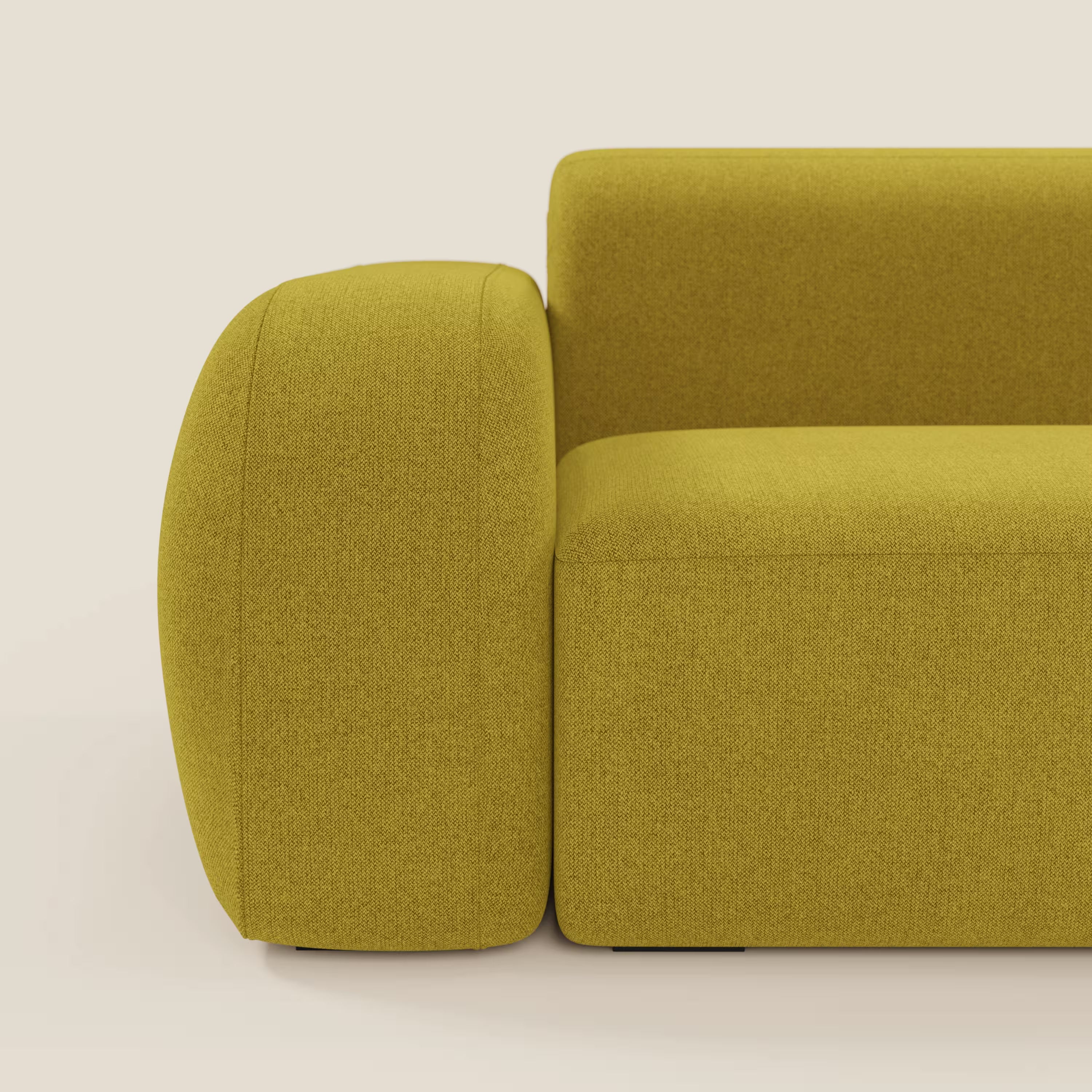 Primo piano del divano angolare componibile e modulare BonBon di Divani.Store in smacchiabile T23 giallo sole, caratterizzato da braccioli e schienale spessi e arrotondati, tessuto strutturato e design minimalista su sfondo beige.