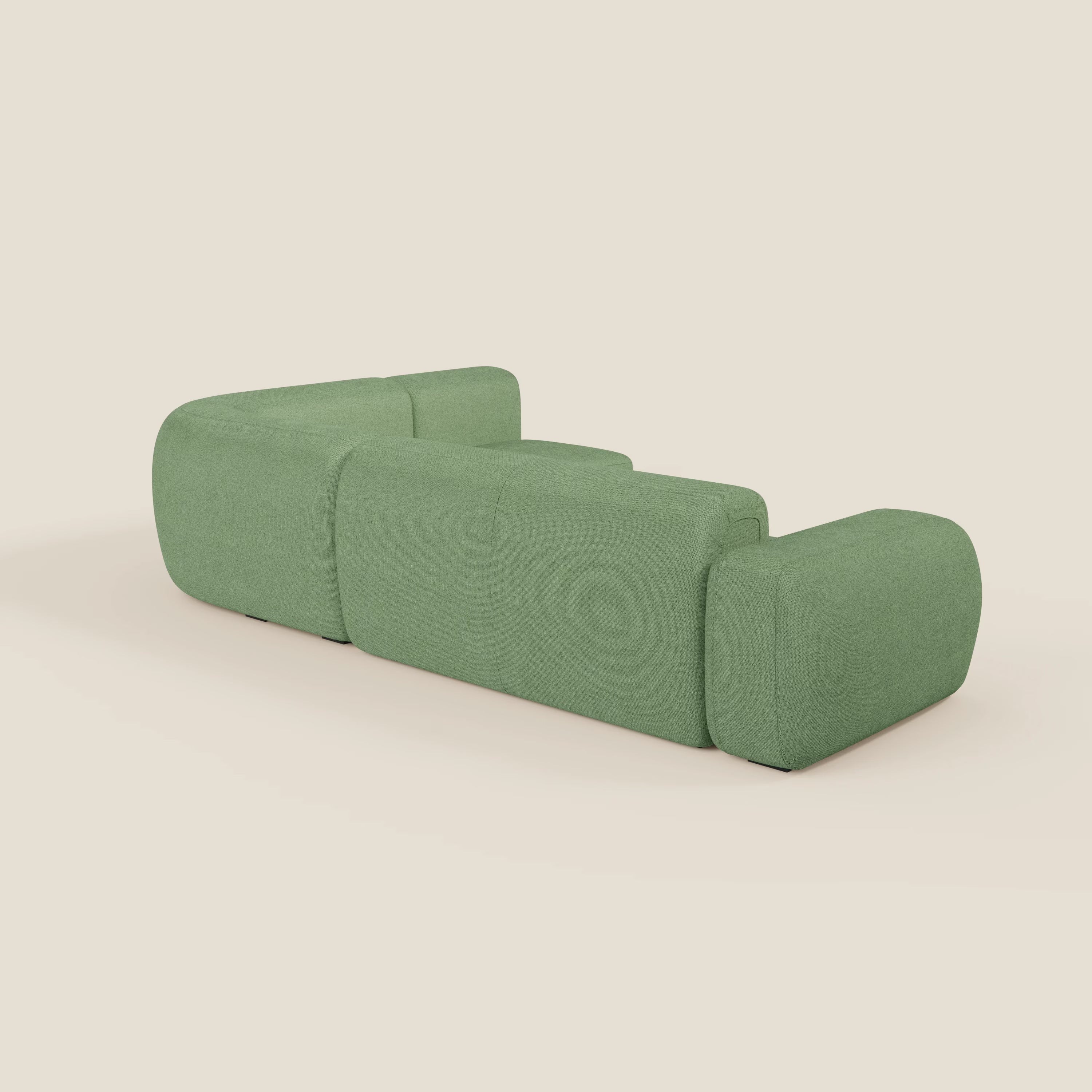 Il divano angolare componibile e modulare BonBon di Divani.Store, in tessuto smacchiabile T23 menta, presenta un design moderno e minimal con cuscini arrotondati e braccioli bassi su sfondo beige, visto da dietro e leggermente angolato a sinistra.