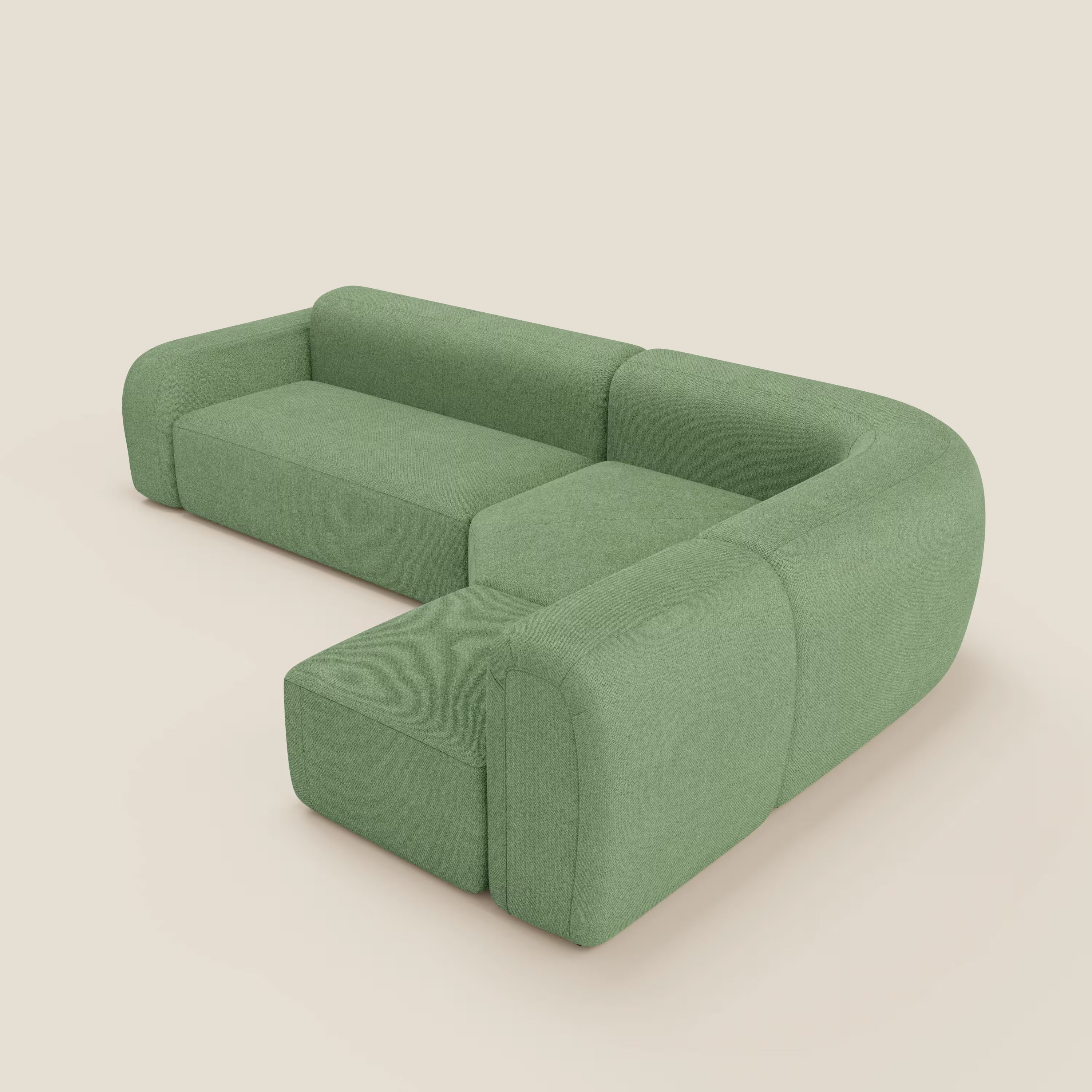 Il divano angolare componibile e modulare BonBon di Divani.Store, in tessuto smacchiabile T23 menta, è caratterizzato da linee pulite, schienale basso, braccioli arrotondati e chaise lounge, perfetto come moderno divano a L su uno sfondo bianco sporco.