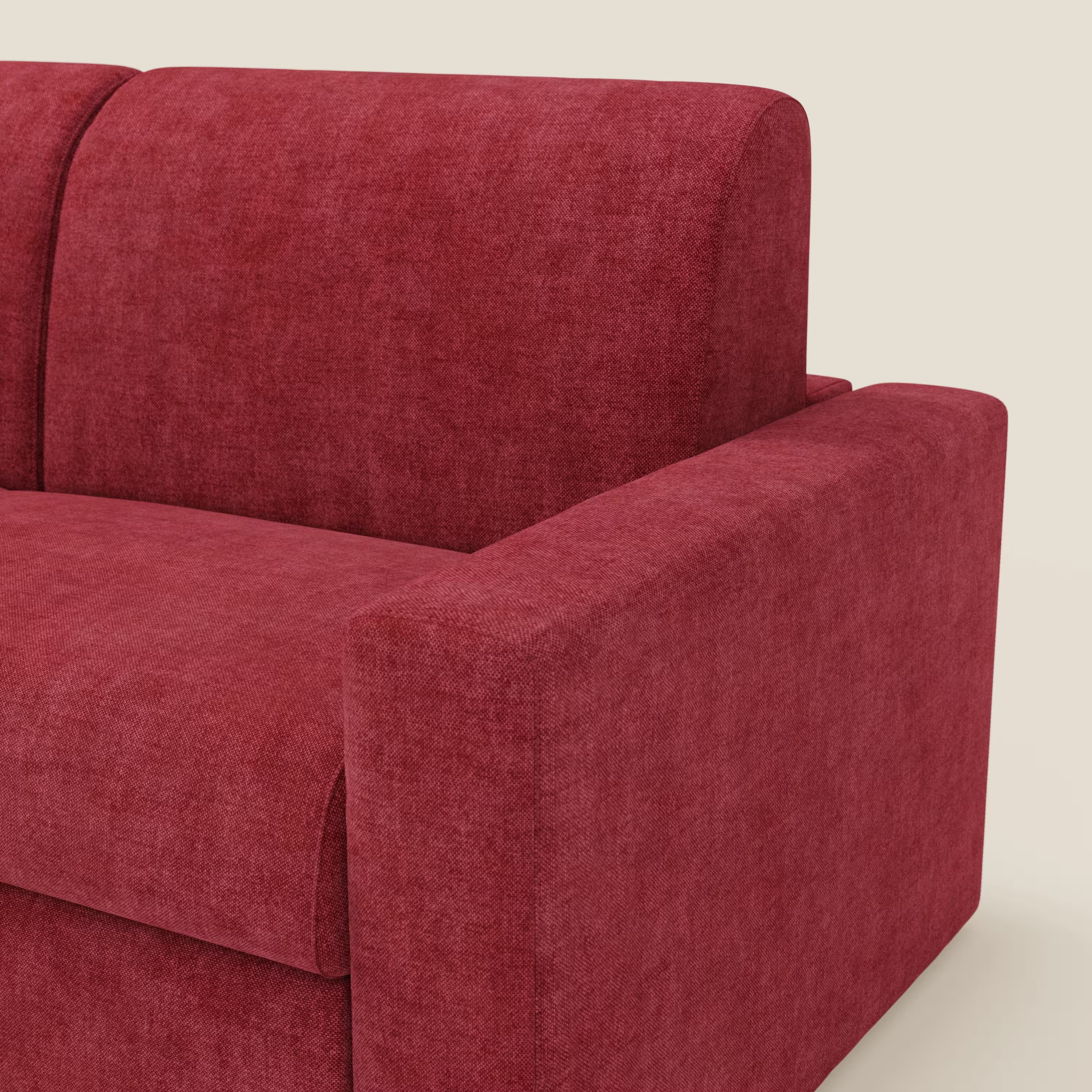 Un primo piano del Diomede Divano letto matrimoniale in velluto easy clean sfoderabile di Divani.Store mostra il tessuto rosso T35 testurizzato, l'ampio bracciolo destro, il cuscino di seduta e lo schienale dalle linee pulite su uno sfondo chiaro.