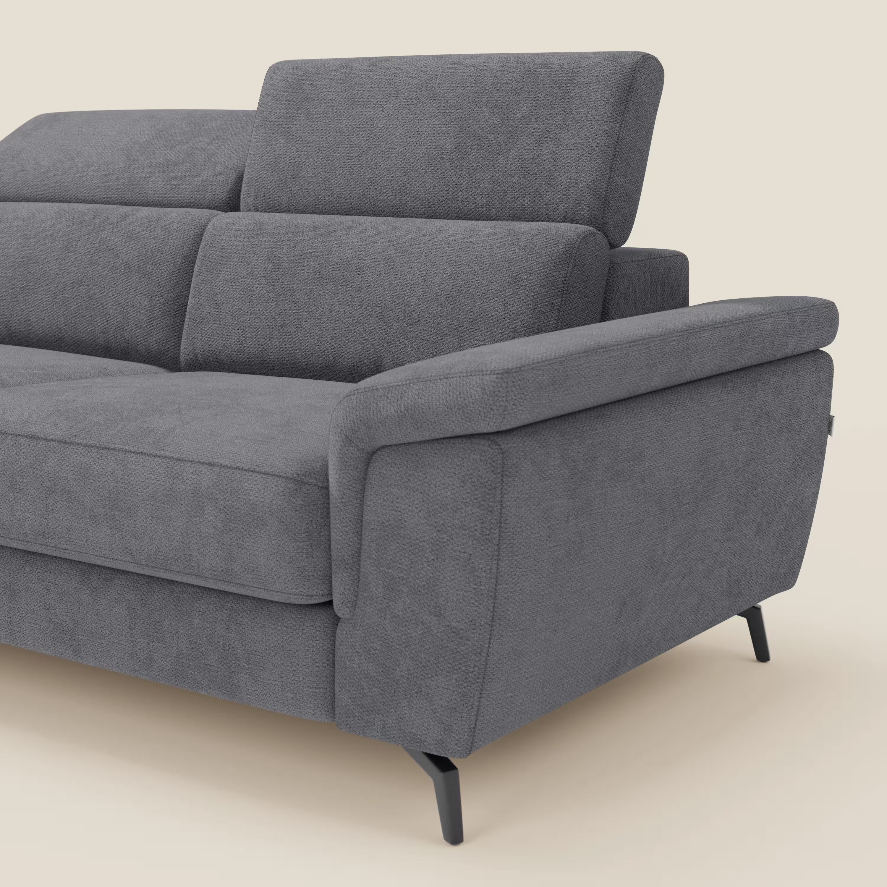 Estro Divano estraibile di Divani.Store in tessuto impermeabile grigio T14 è dotato di chaise-longue, poggiatesta reclinabili, ampio bracciolo imbottito e sottili gambe in metallo nero. In figura: lato destro e seduta parziale su sfondo beige.