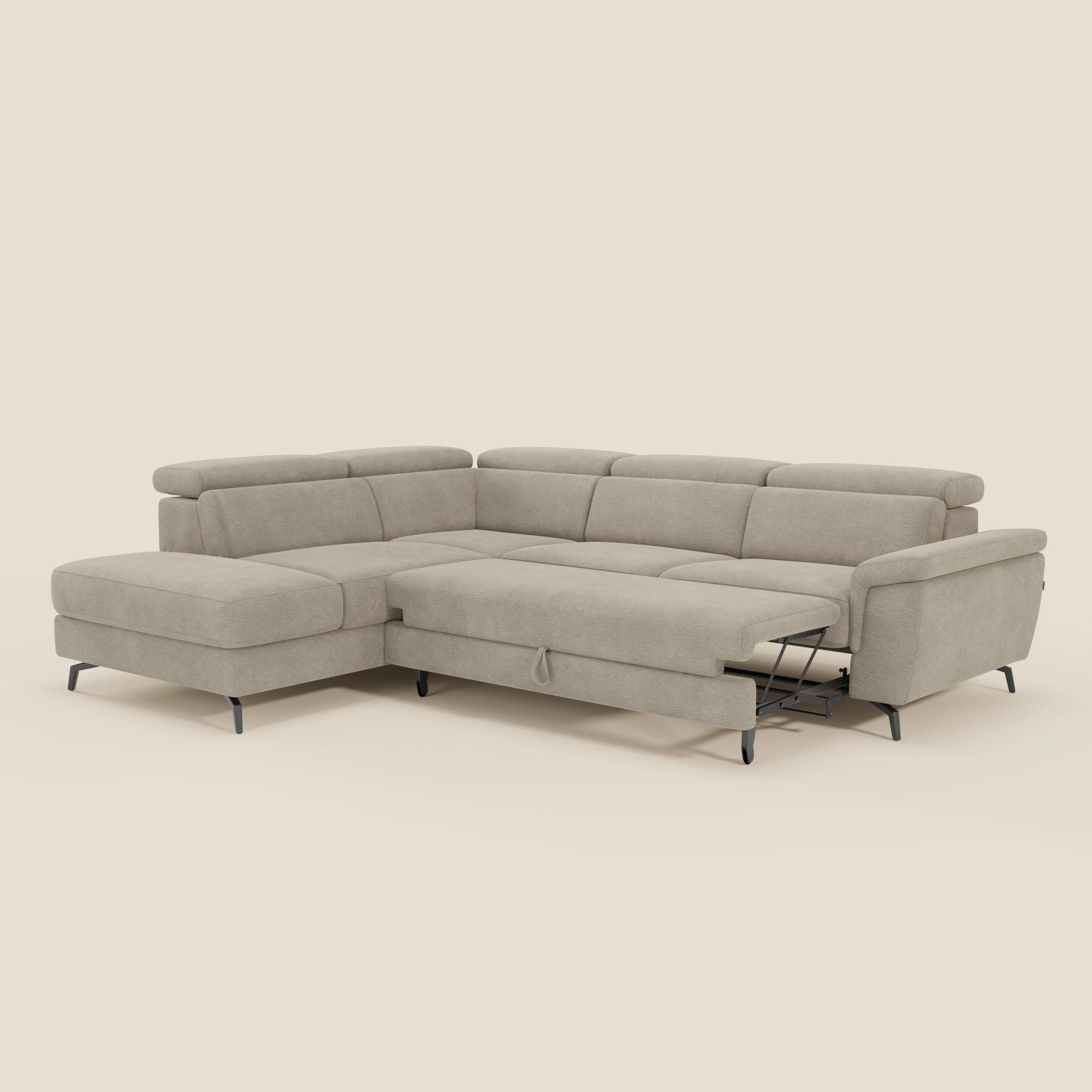 Il divano angolare estraibile Estro di Divani.Store è caratterizzato da una poggiatesta reclinabile e da una seduta estraibile a destra, in tessuto impermeabile T14 beige con sottili gambe in metallo nero, su uno sfondo liscio color crema.