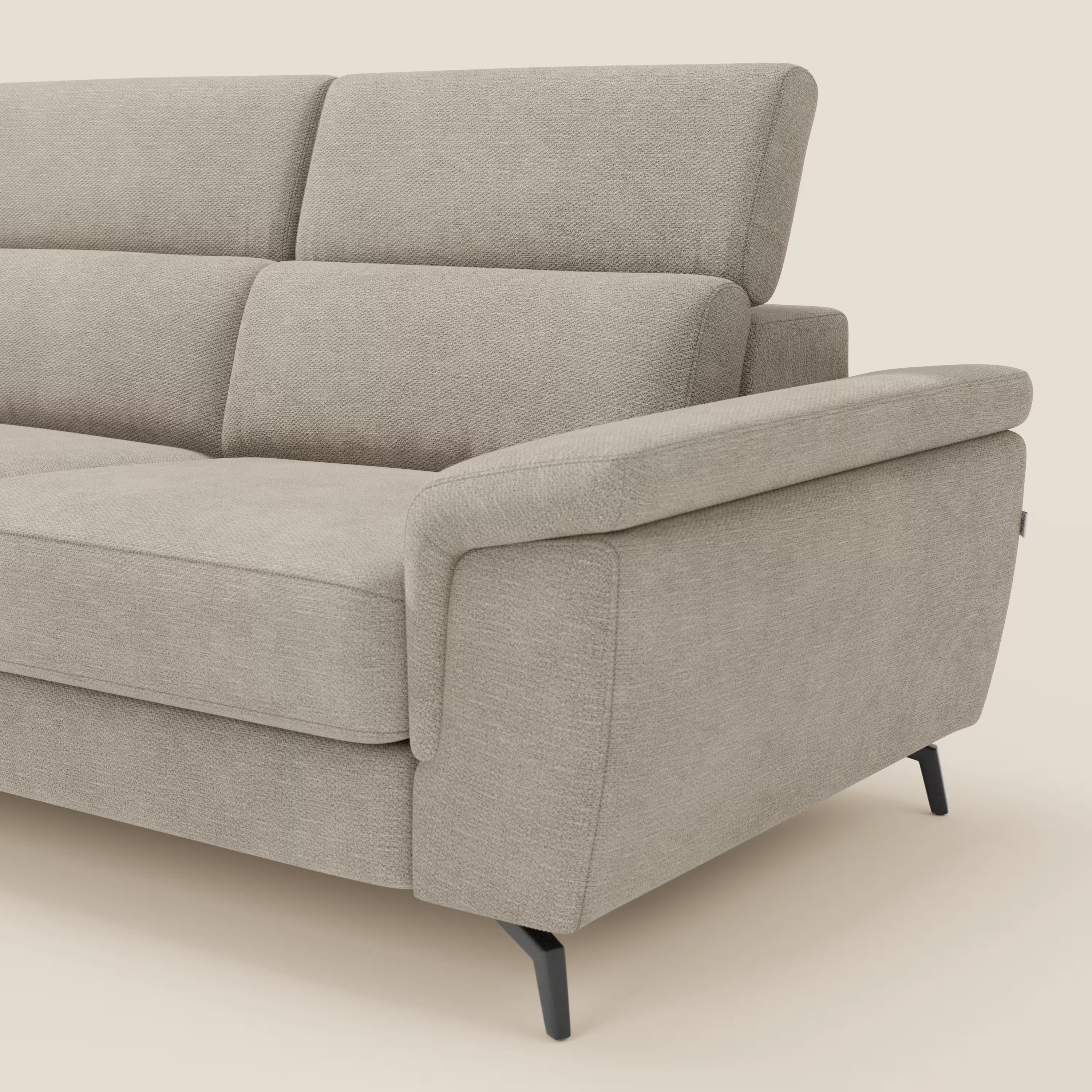 Primo piano di Estro Divano angolare estraibile di Divani.Store in tessuto impermeabile beige T14, con poggiatesta regolabile, ampio bracciolo, seduta estraibile, gambe nere sottili e un design elegante e contemporaneo su uno sfondo bianco sporco.
