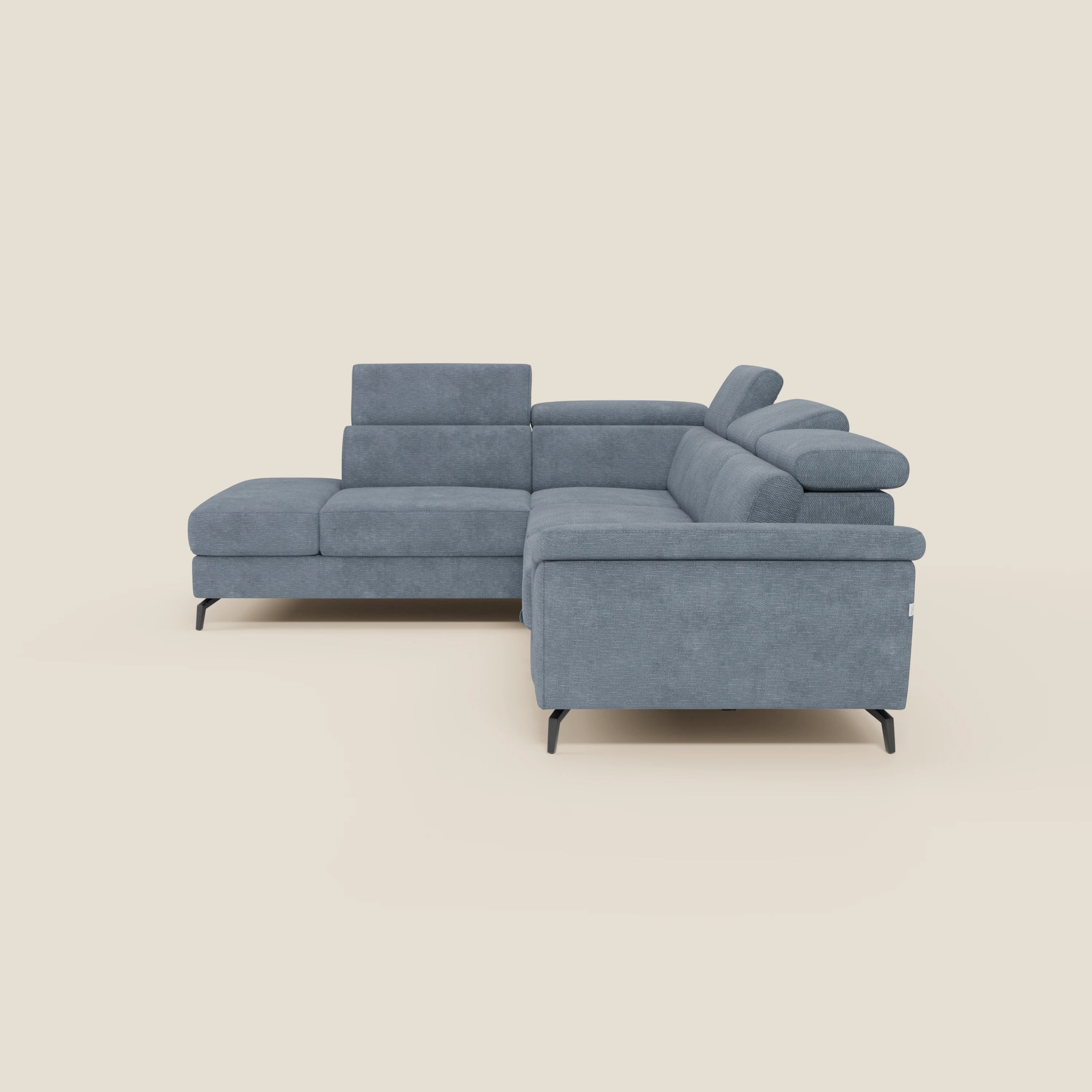 Il divano angolare estraibile Estro di Divani.Store è caratterizzato da poggiatesta reclinabili, ampi braccioli, cuscini morbidi e gambe in metallo nero con tessuto impermeabile T14 carta da zucchero. La chaise longue si estende a sinistra su uno sfondo beige.