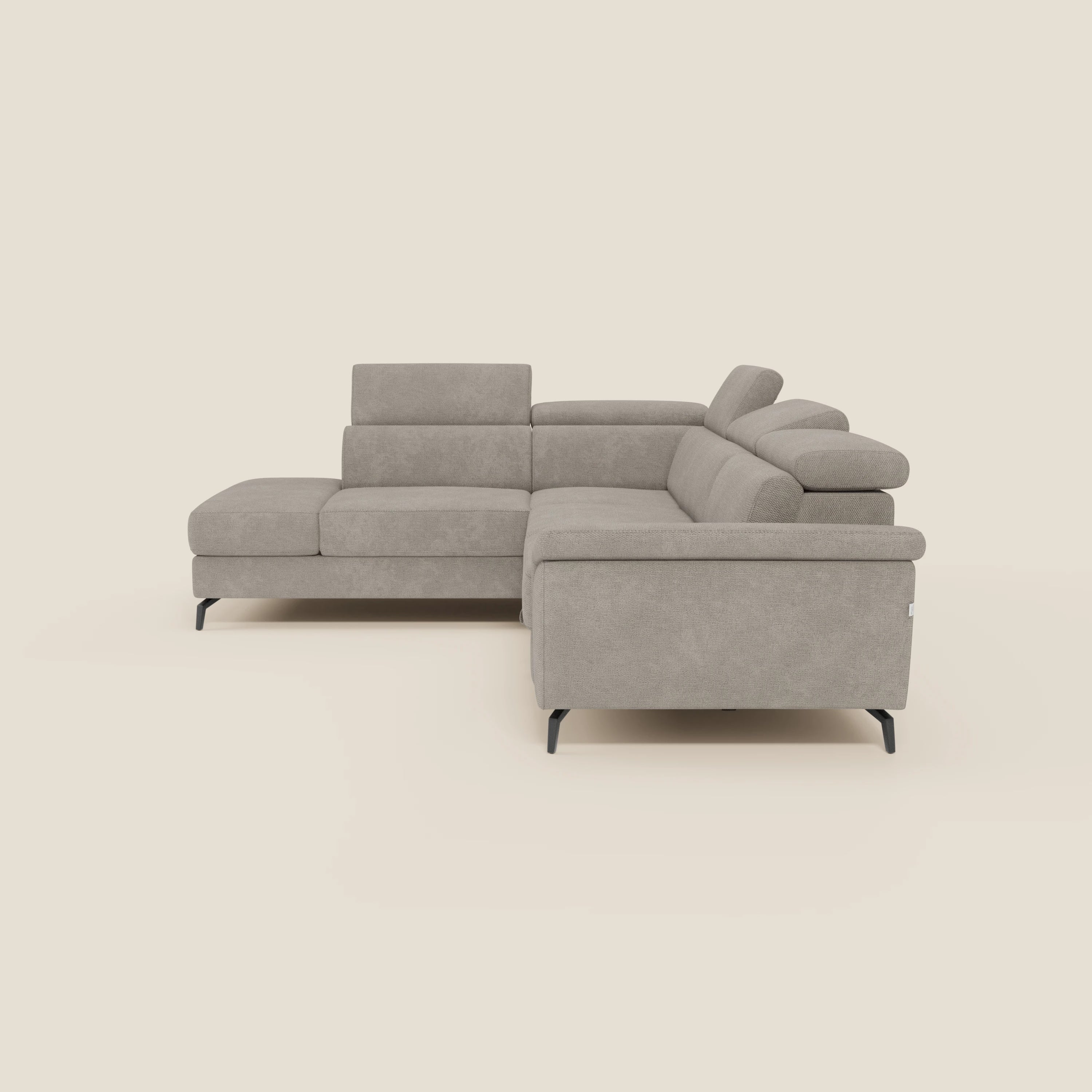 Il divano angolare estraibile Estro di Divani.Store è caratterizzato da poggiatesta reclinabili, braccioli bassi e gambe sottili in metallo nero con tessuto impermeabile T14 tortora. Design elegante e minimale presentato su uno sfondo bianco sporco.