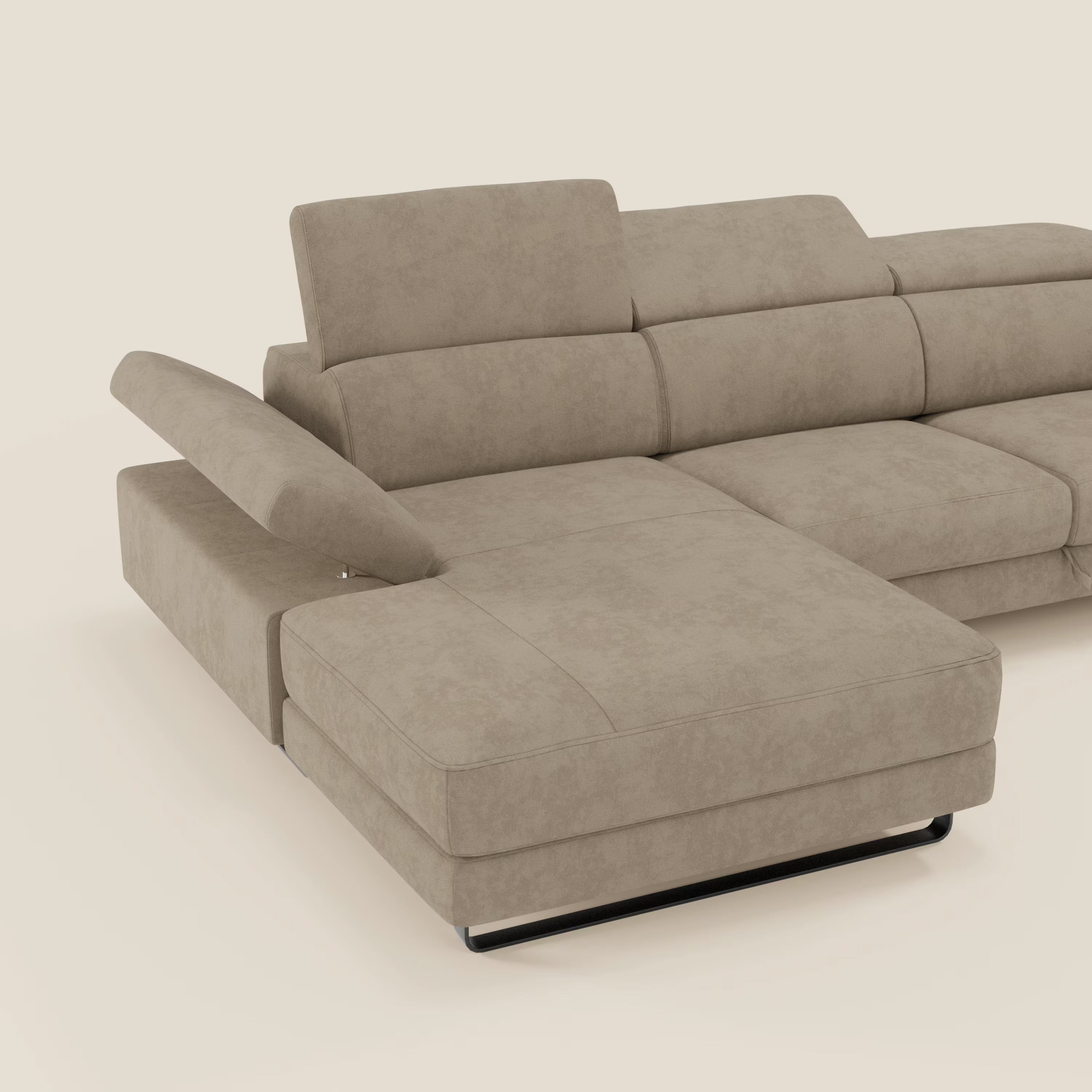 Il divano angolare estraibile Zayana di Divani.Store è caratterizzato da braccioli e poggiatesta reclinabili in tessuto impermeabile T02 beige, con poggiatesta regolabili, sedute fisse imbottite e gambe basse nere. In foto, su sfondo bianco sporco.