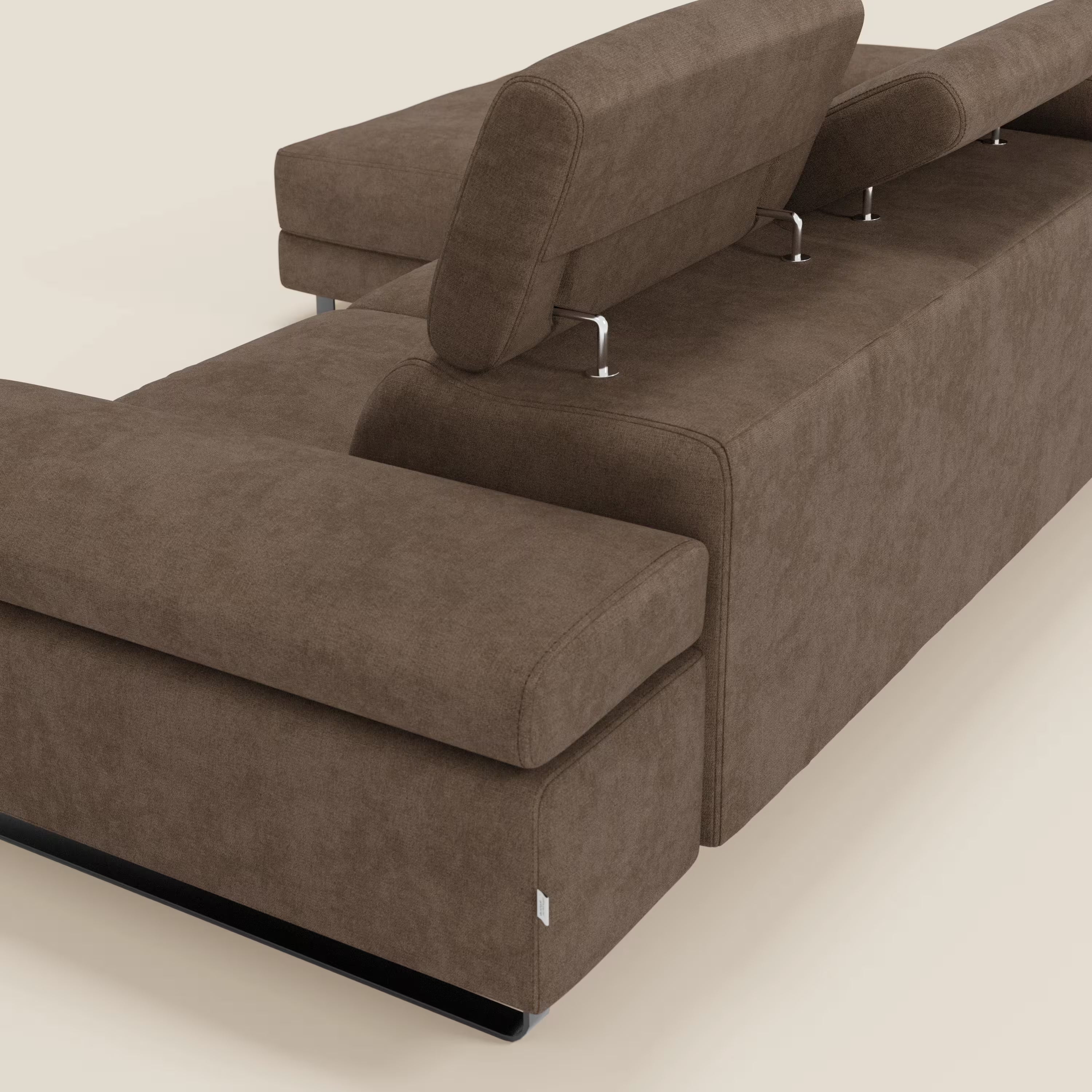 Il divano angolare estraibile Zayana di Divani.Store è caratterizzato da ampi braccioli, chaise longue sinistra e poggiatesta regolabili con supporti in metallo. Rivestito in tessuto impermeabile T02 marrone, si colloca su uno sfondo beige chiaro.