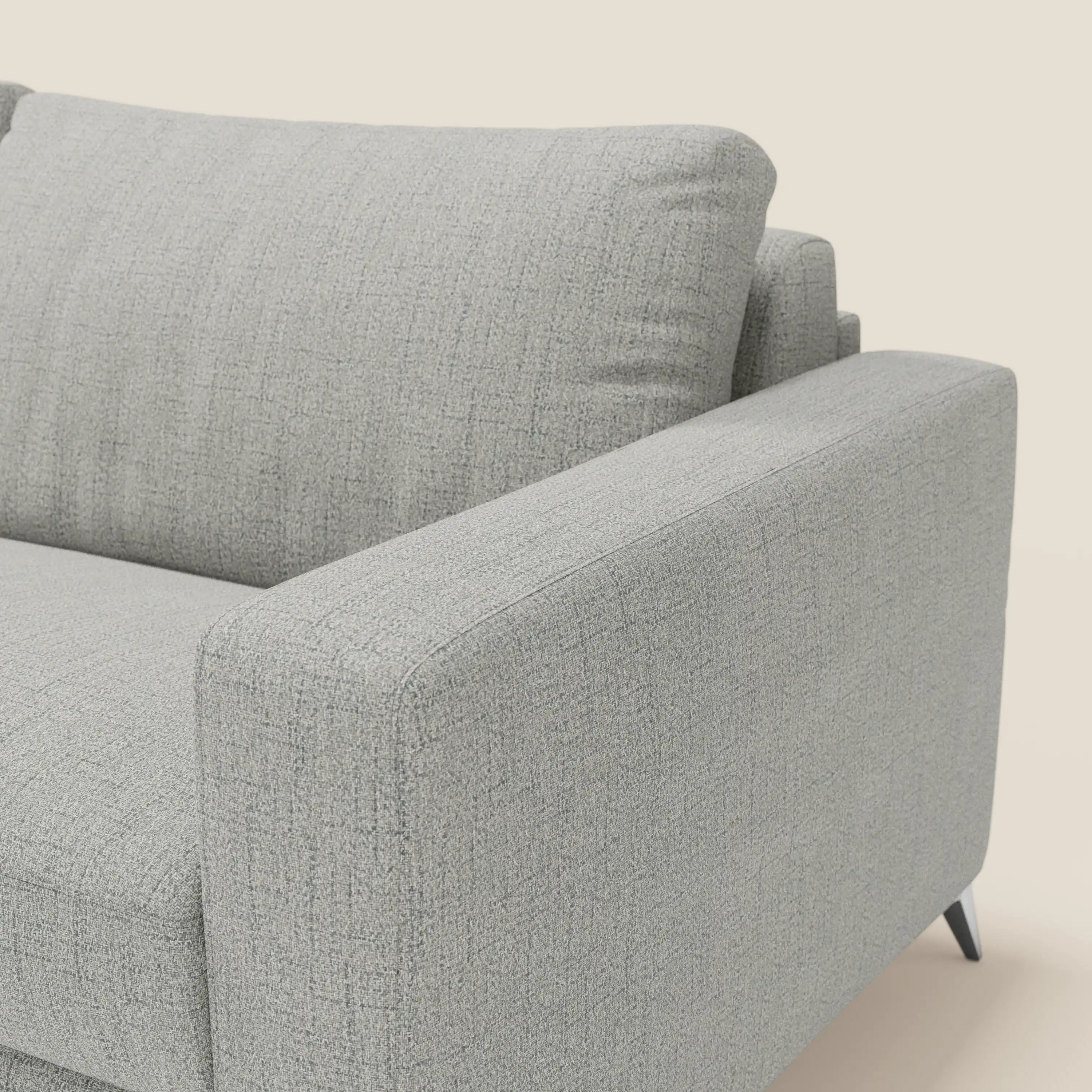 Primo piano del letto matrimoniale Alaya Divano di Divani.Store in impermeabile T03 grigio chiaro. L'immagine evidenzia il bracciolo destro, i morbidi cuscini della seduta e dello schienale, le linee pulite e le gambe angolari nere su uno sfondo chiaro.