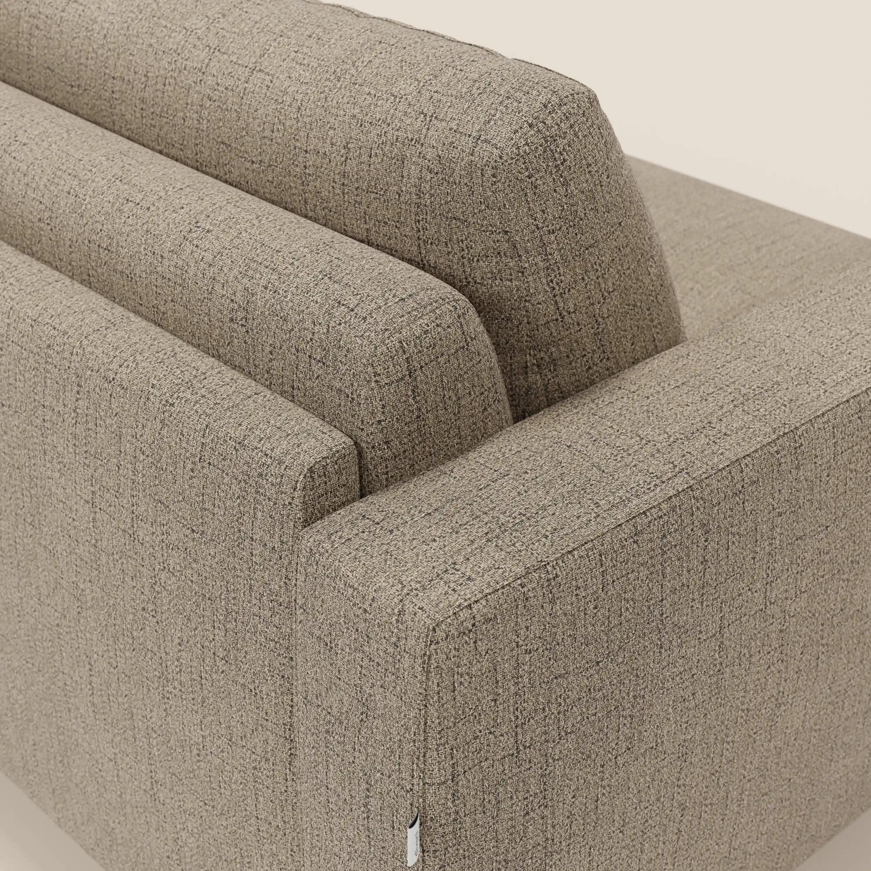 Un primo piano del divano letto matrimoniale Alaya di Divani.Store, caratterizzato da morbidi schienali e braccioli imbottiti in tessuto T03 marrone testurizzato e impermeabile, mostra linee moderne e comfort quotidiano su un semplice sfondo bianco sporco.