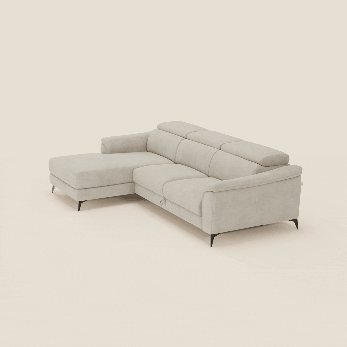 L'Arcos Divano con penisola di Divani.Store in T11 panna offre gambe alte, poggiatesta reclinabili e rivestimento in microfibra impermeabile, mettendo in mostra l'artigianato italiano su un semplice sfondo bianco sporco.