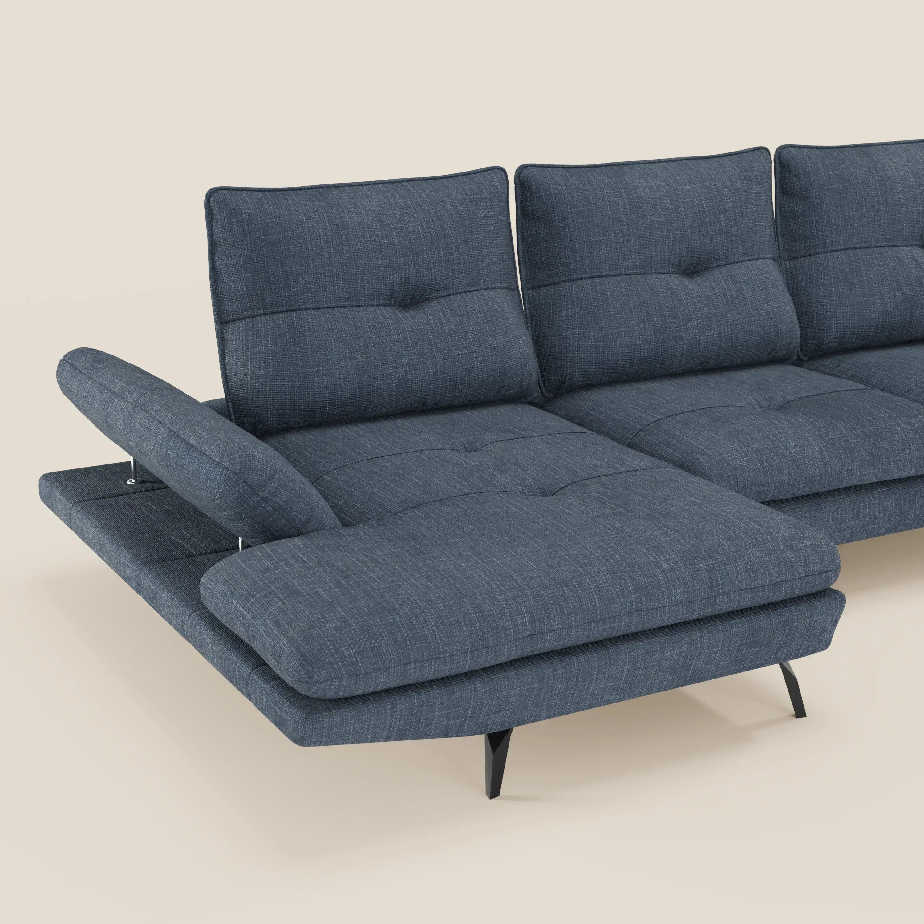 Un Divano con penisola Ardex di Divani.Store, in tessuto impermeabile T06 blu con schuienali traslanti e braccioli regolabili, è mostrato su uno sfondo beige semplice. È visibile solo una parte del divano componibile.