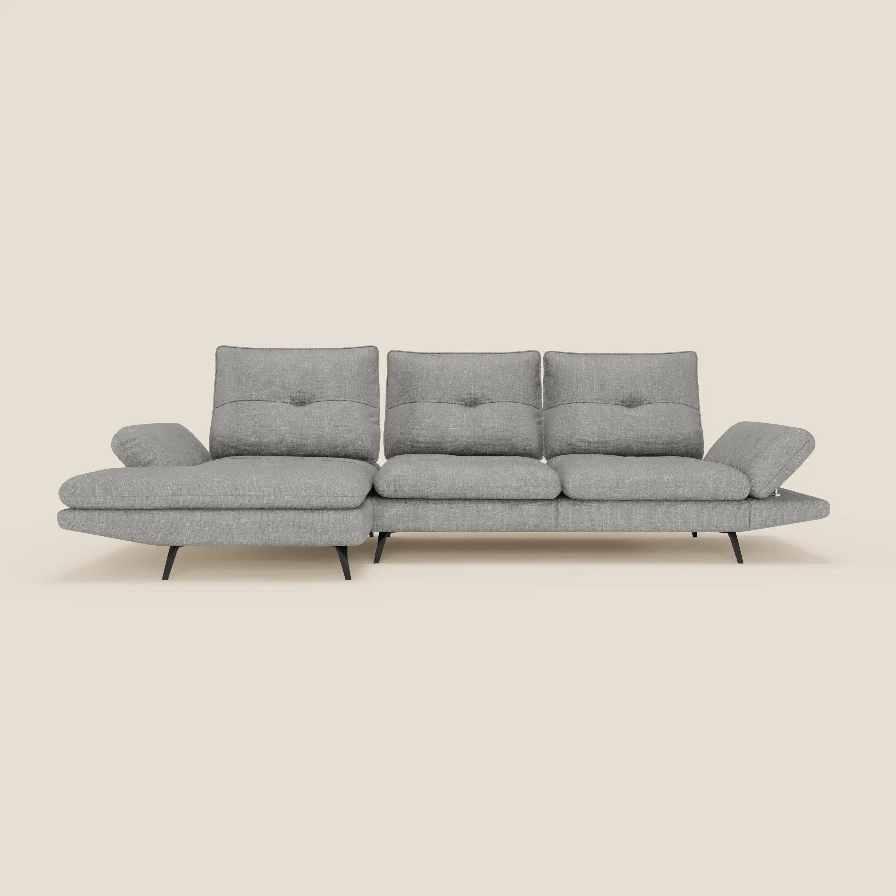 L'Ardex Divano con penisola di Divani.Store è caratterizzato da un elegante tessuto impermeabile grigio T06, schienali scorrevoli, braccioli regolabili, gambe affusolate nere e una chaise longue a sinistra, su sfondo beige.