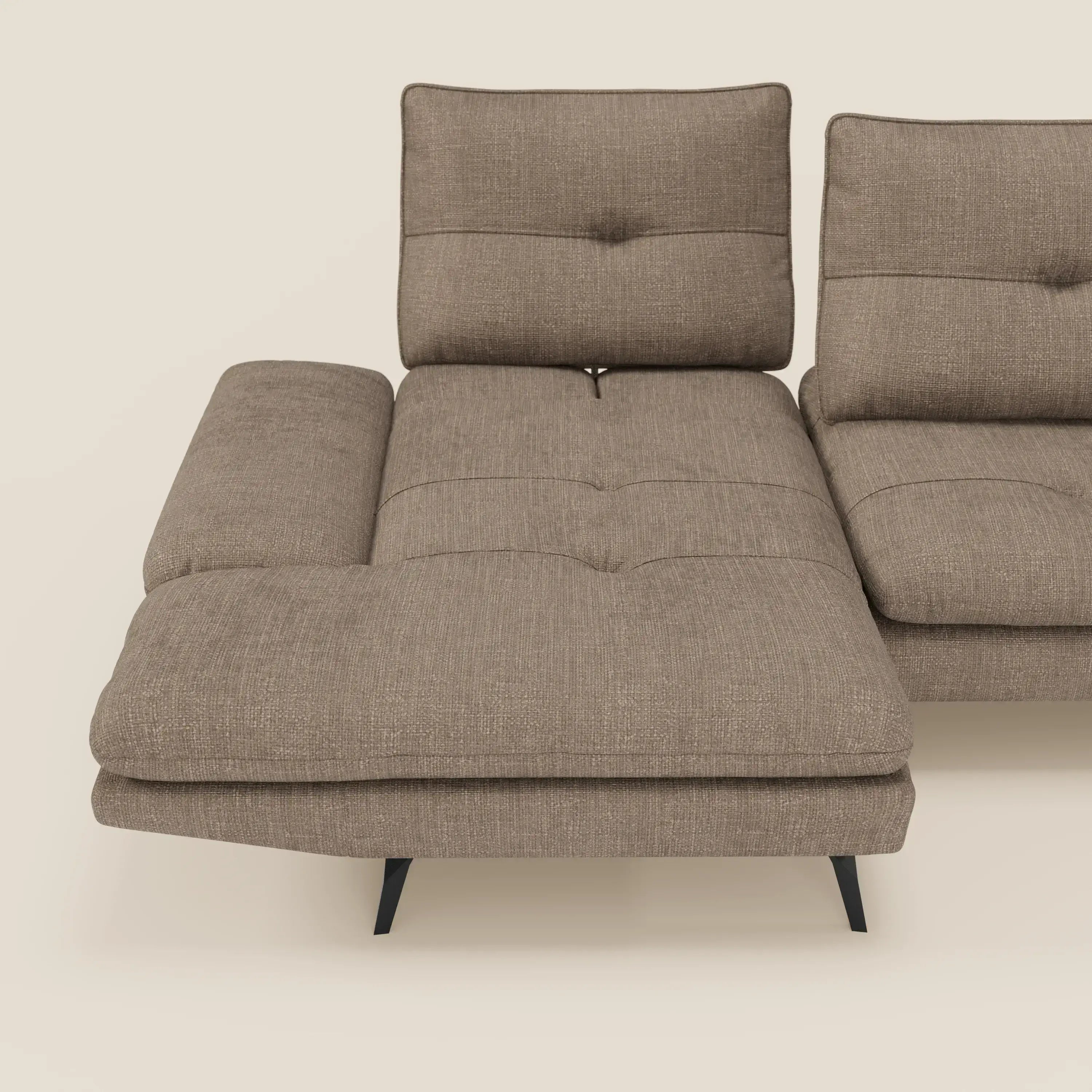 Ardex Divano con penisola di Divani.Store è un moderno divano marrone in tessuto impermeabile T06, con schienali scorrevoli, braccioli regolabili e chaise longue sinistra. Presenta tre cuscini trapuntati e sottili gambe nere su sfondo beige.