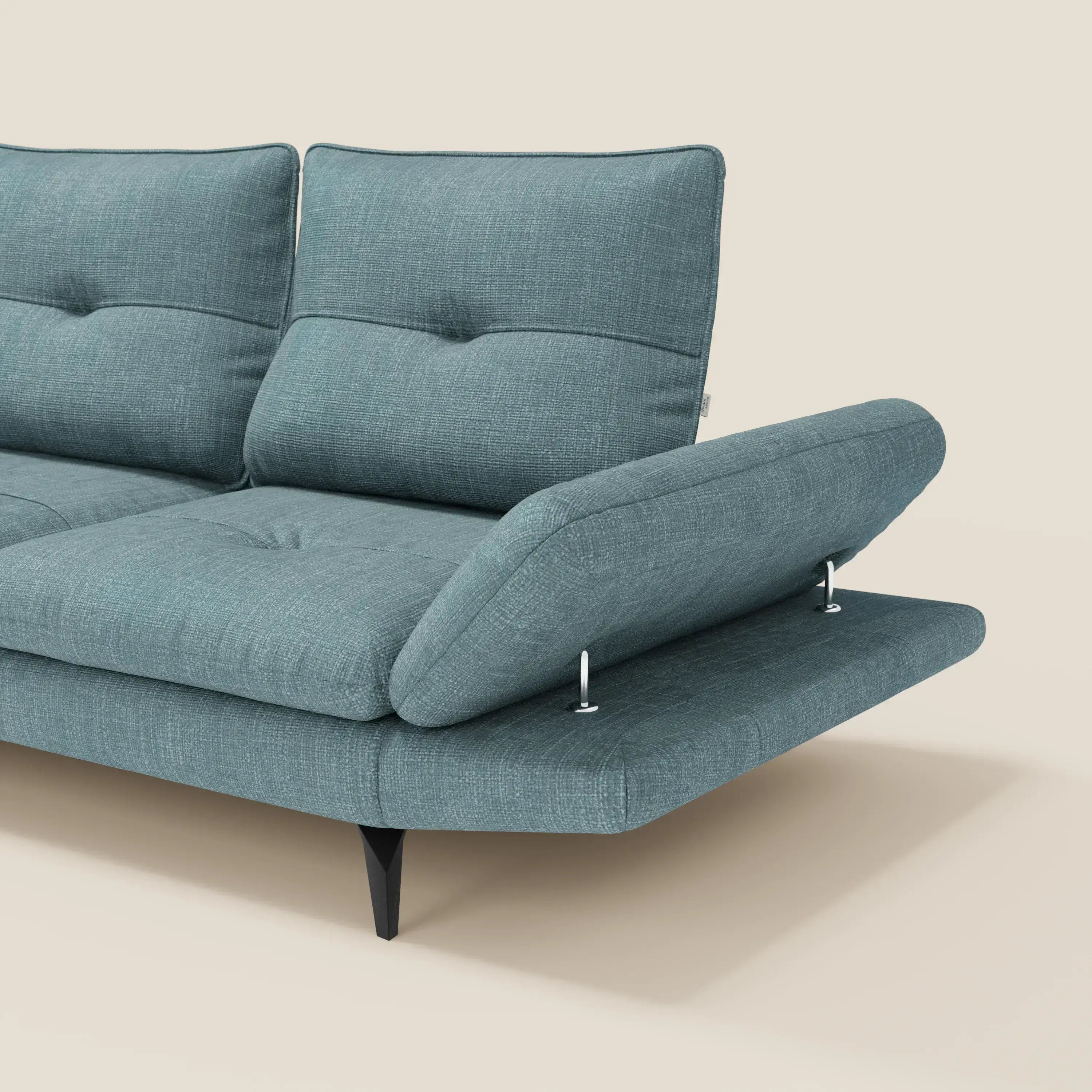 Il Divano Angolare Ardex di Divani.Store, presentato in tessuto impermeabile T06 azzurro, è caratterizzato da sedile/schienale trapuntato, supporti cromati angolati, gambe affusolate nere e bracciolo regolabile destro inclinato verso l'alto su uno sfondo beige chiaro. Solo una parte è visibile.