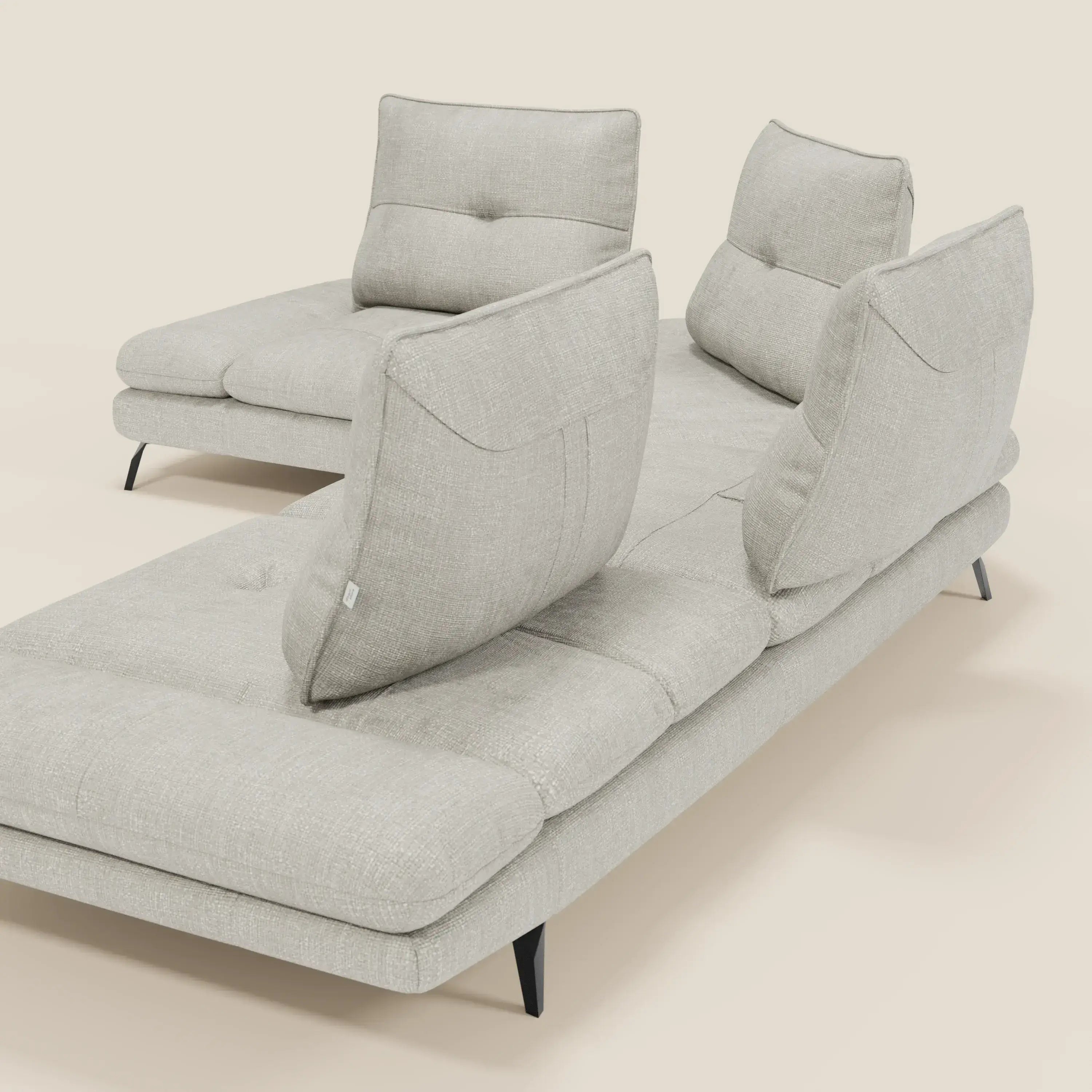 Ardex Divano Angolare di Divani.Store è caratterizzato da schienali traslanti, bracciolo regolabile e sottili gambe nere in tessuto impermeabile T06 grigio chiaro, su uno sfondo chiaro. Il suo design minimalista comprende cuscini con ciuffi e rivestimenti testurizzati.