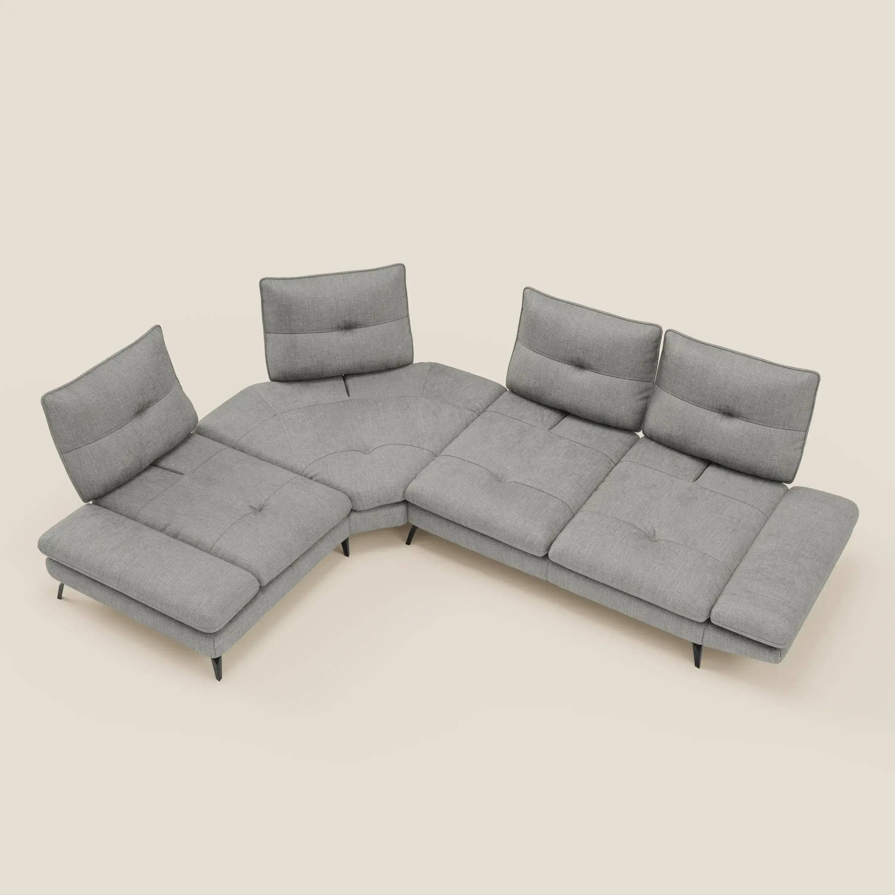 Ardex Divano Angolare di Divani.Store è un moderno divano componibile in tessuto impermeabile grigio chiaro T06, caratterizzato da tre ampie sedute, schienali traslanti, bracciolo regolabile, sottili gambe nere e sottili cuscini trapuntati su sfondo beige.