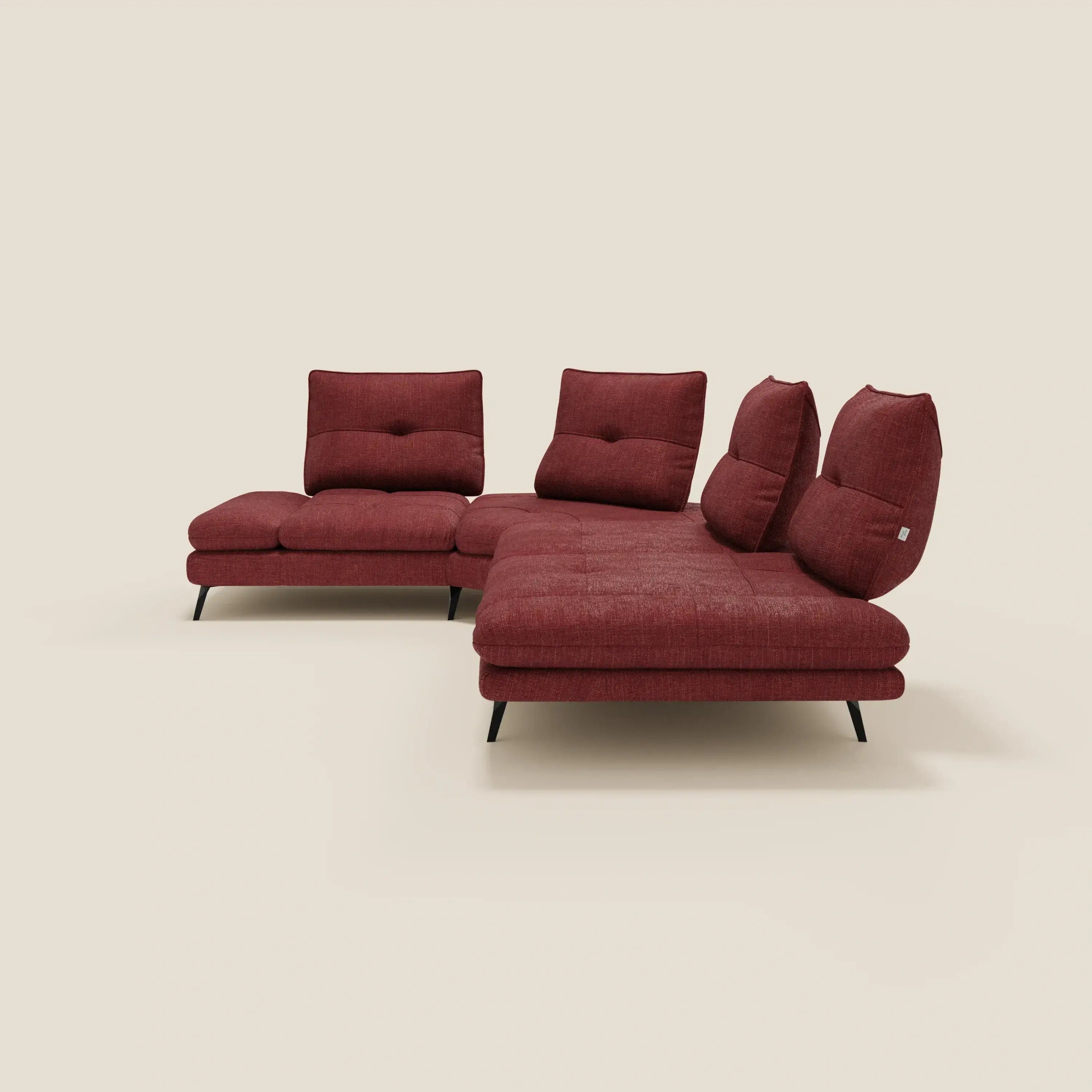 Ardex Divano Angolare di Divani.Store è caratterizzato da tre schienali scorrevoli, un bracciolo mobile e un elegante tessuto impermeabile T06 rosso intenso. Ha cuscini in lavorazione capitonné, due ampie sedute, sottili gambe nere e un semplice sfondo beige.