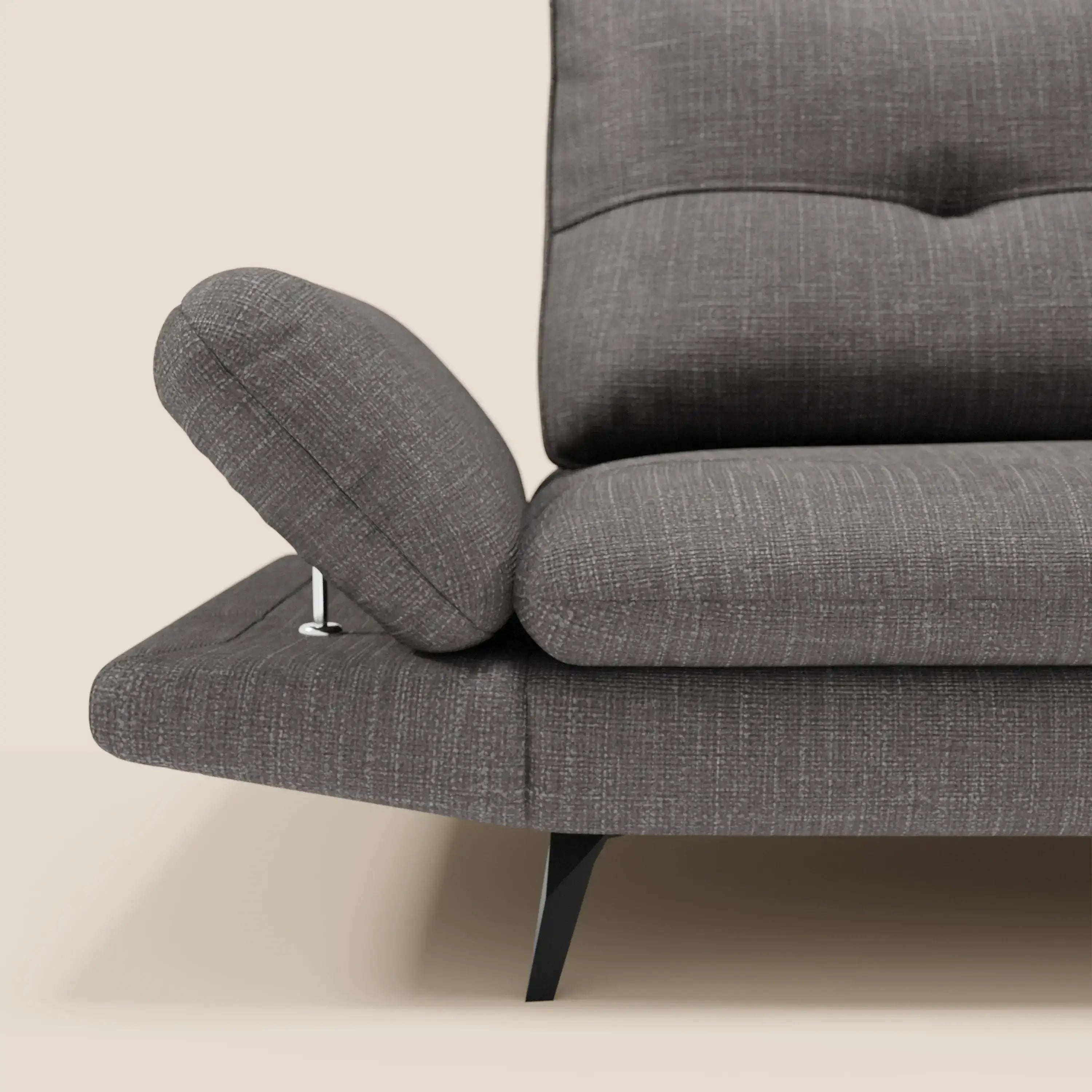 Primo piano del divano Ardex Divano 3 posti di Divani.Store in tessuto impermeabile T06 antracite. Braccioli regolabili, schienali traslanti, gambe angolate nere e cuscini imbottiti su sfondo beige chiaro.