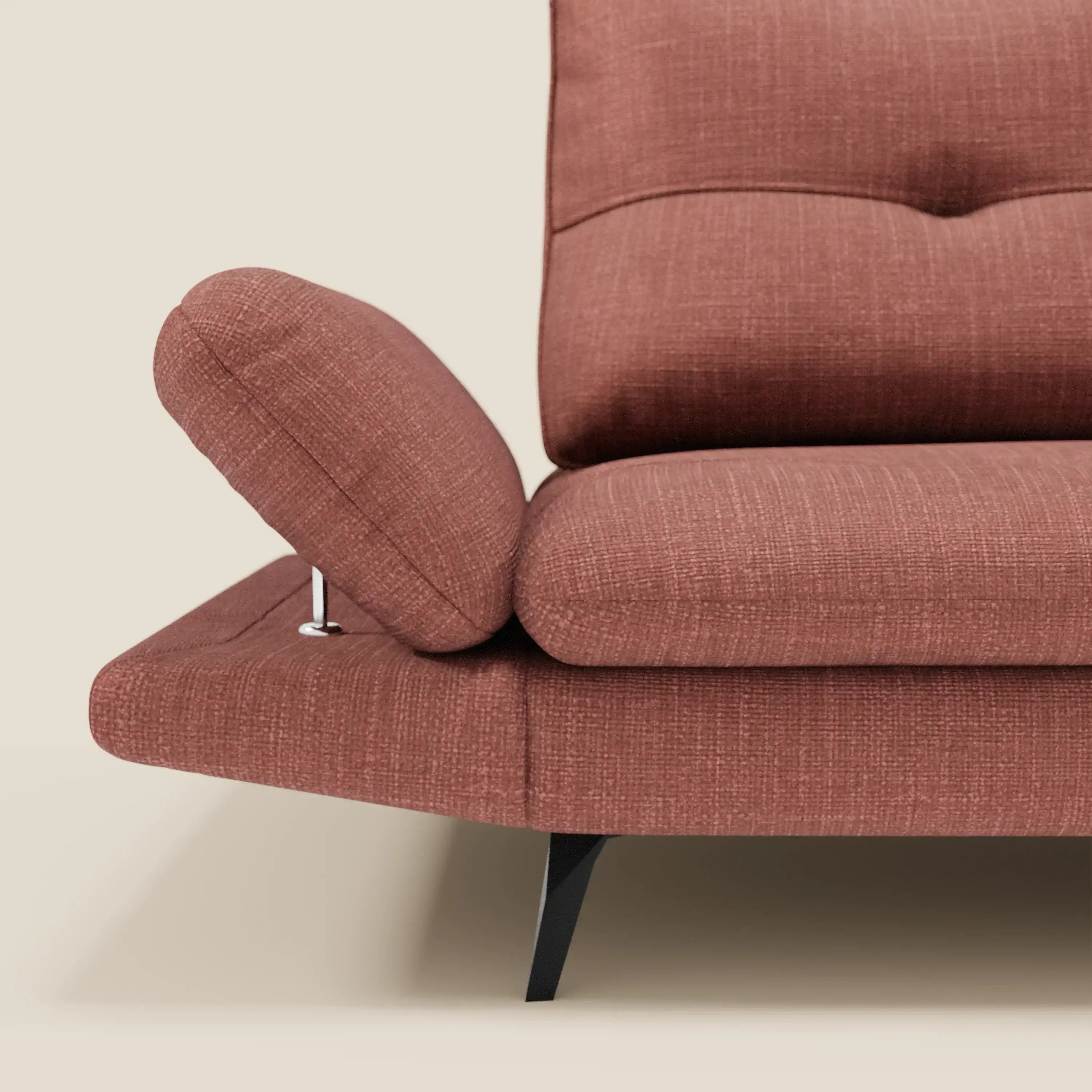 Primo piano di Ardex Divano 3 posti di Divani.Store in morbido tessuto impermeabile T06 corallo, con schienali traslanti, braccioli regolabili, cuscini trapuntati e gambe angolari nere su sfondo beige chiaro.