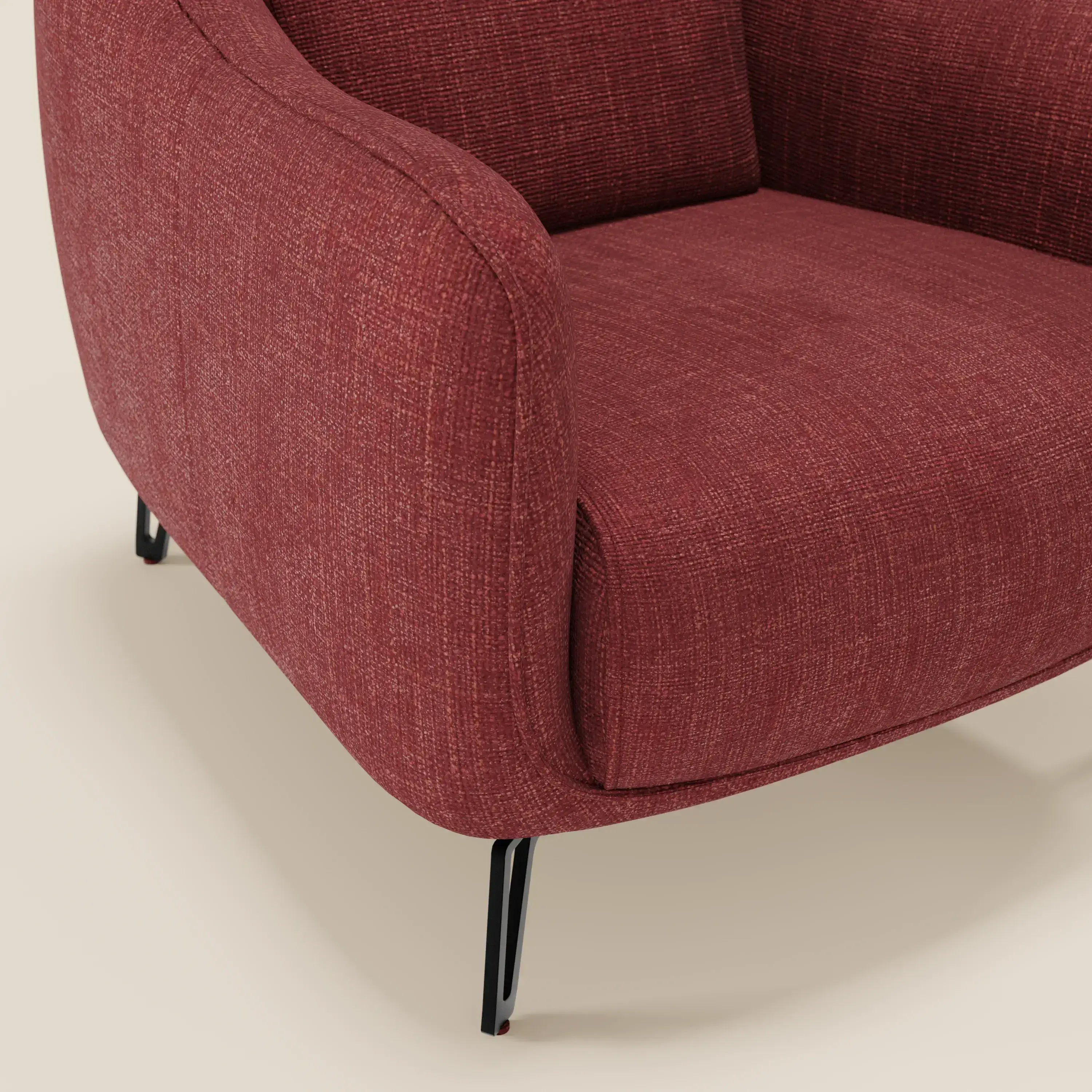 Primo piano di Avela Poltroncina di Divani.Store, una seduta dal comfort intramontabile in morbido tessuto impermeabile T06 rosso con bordi arrotondati ed eleganti gambe in metallo nero, su uno sfondo chiaro.
