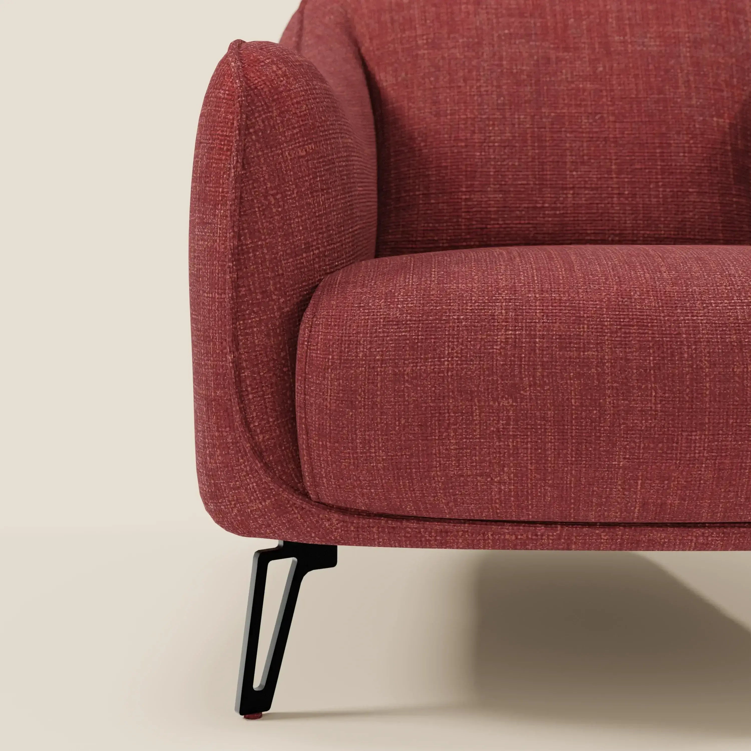 Primo piano di Avela Poltroncina di Divani.Store, con tessuto impermeabile rosso T06, bracciolo sinistro, cuscino di seduta e gamba angolata in metallo nero. Le sue linee morbidamente arrotondate esaltano il comfort e l'eleganza senza tempo di questa sedia moderna.
