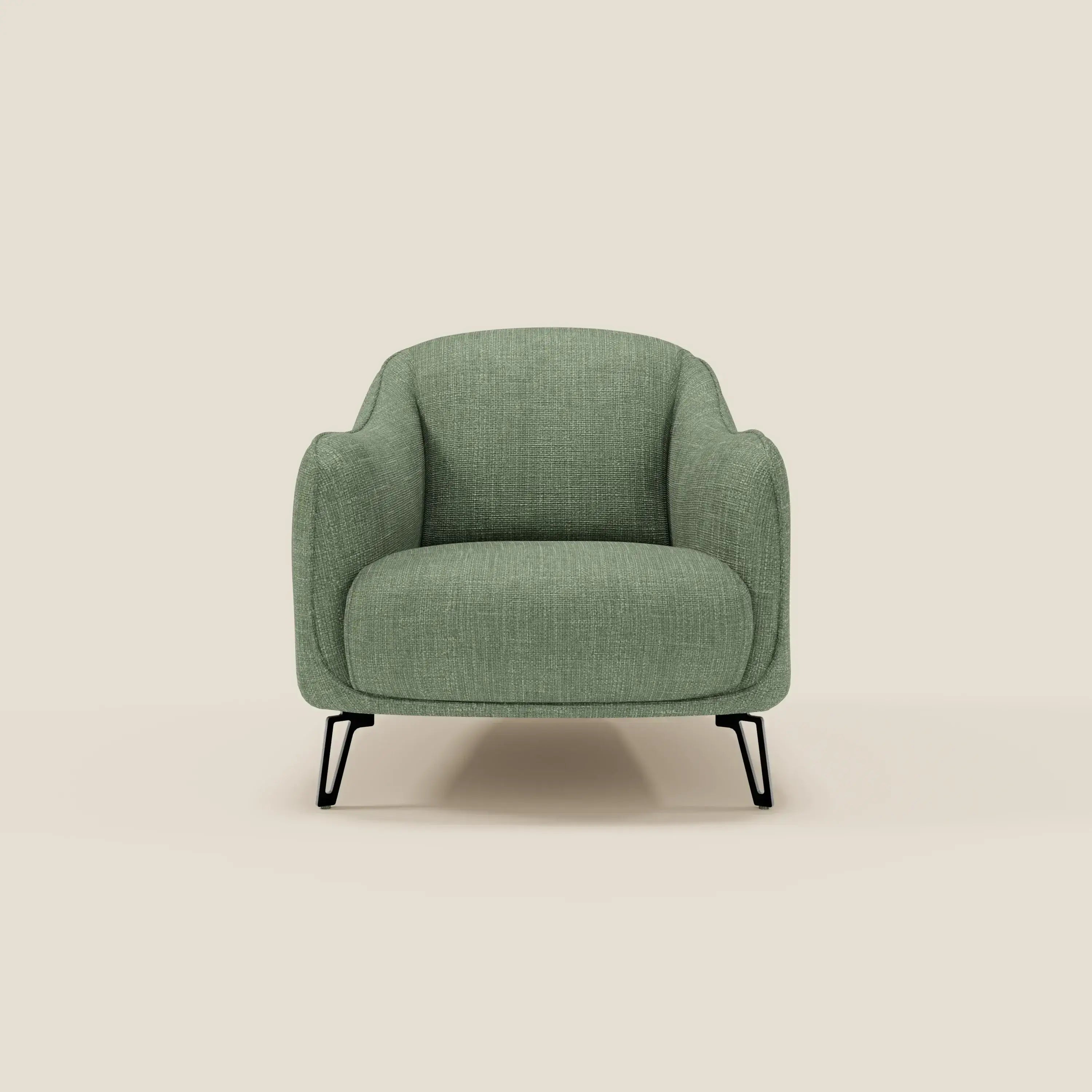La poltroncina Avela di Divani.Store, dal comfort senza tempo, è realizzata in morbido tessuto impermeabile T06 verde con schienale e braccioli curvi e gambe in metallo nero sottile, su sfondo beige neutro.