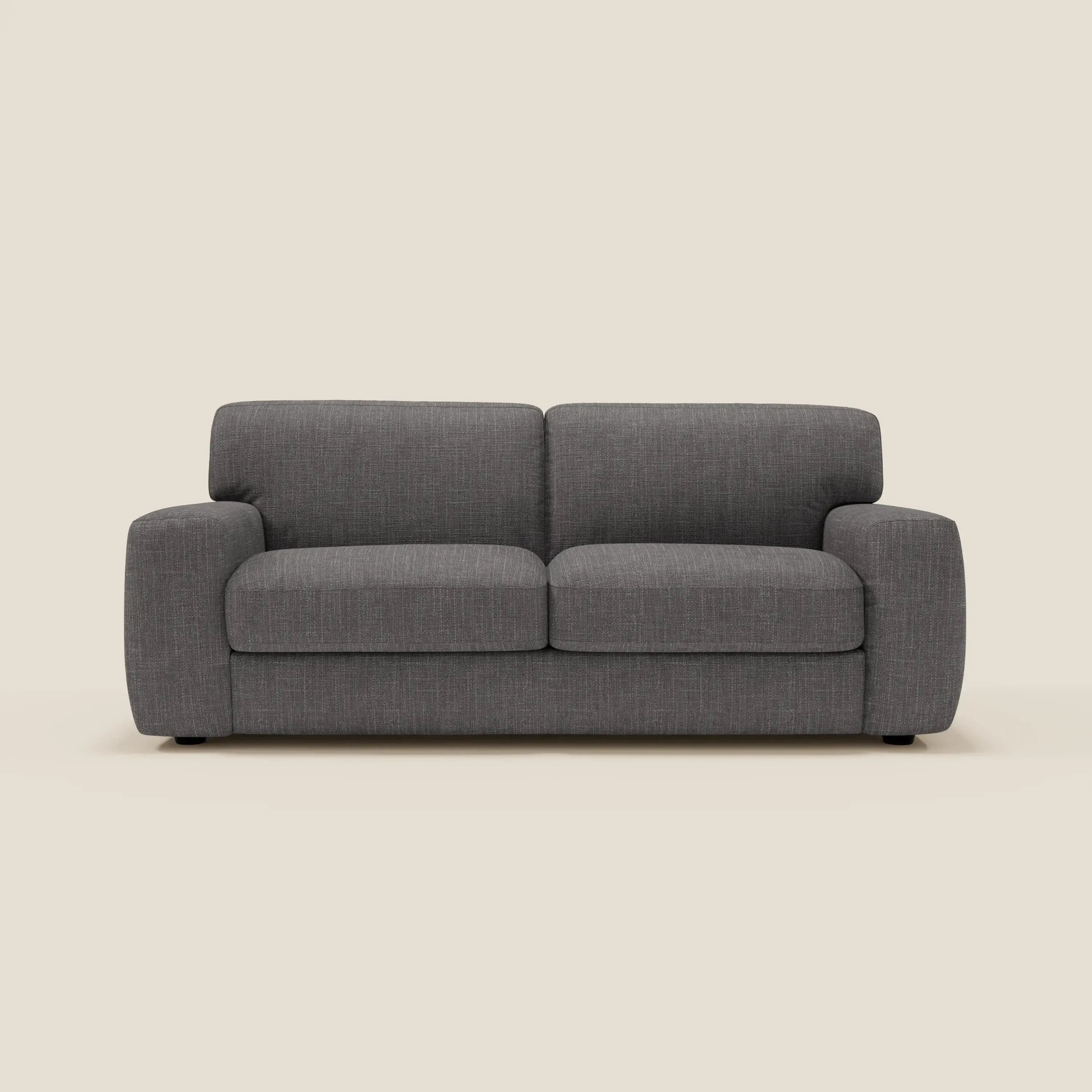 Il letto materasso Cloud Divano H17 cm di Divani.Store è caratterizzato da morbidi cuscini in tessuto impermeabile T06 antracite e da un design moderno e squadrato con ampi braccioli per un comfort quotidiano, su uno sfondo bianco sporco.