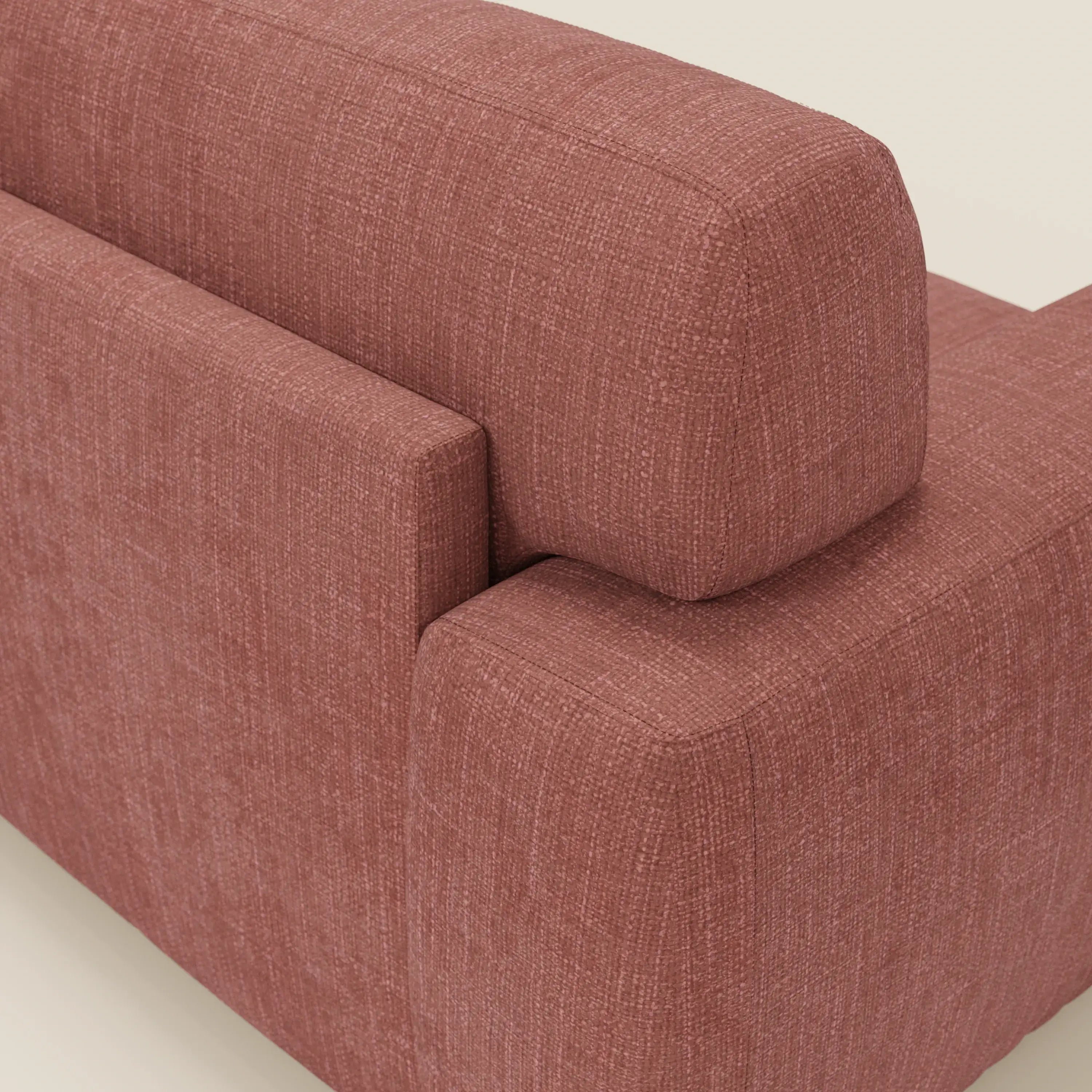 Un primo piano angolato del letto materasso Cloud Divano H17 cm di Divani.Store, rivestito in tessuto impermeabile T06 corallo, mostra cuscini morbidi, linee pulite e una trama sottile su uno sfondo bianco sporco.