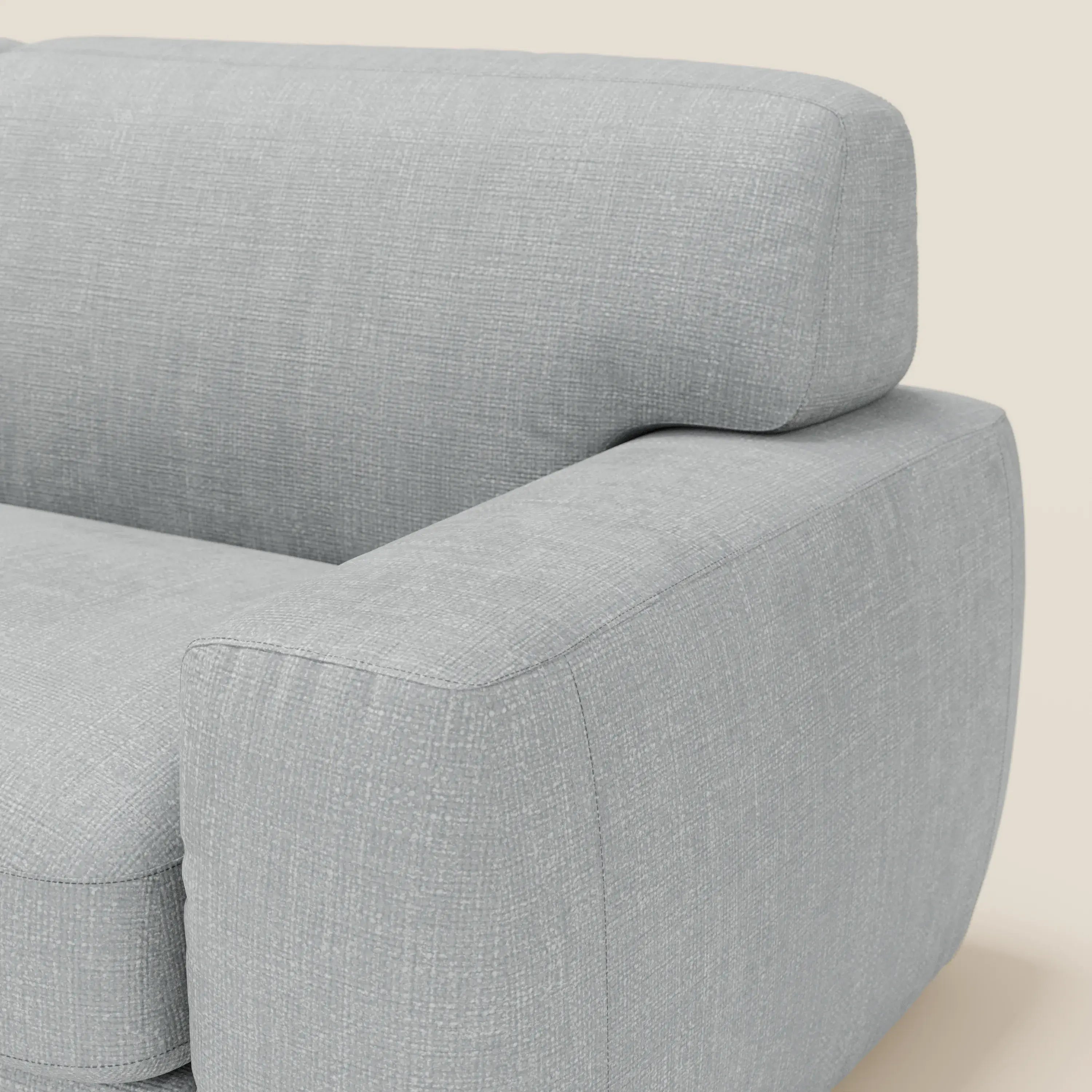 Primo piano del divano letto materasso Cloud H17 cm di Divani.Store in tessuto impermeabile T06 ghiaccio, che mostra l'ampio bracciolo, lo schienale imbottito e il moderno design squadrato su uno sfondo beige neutro.