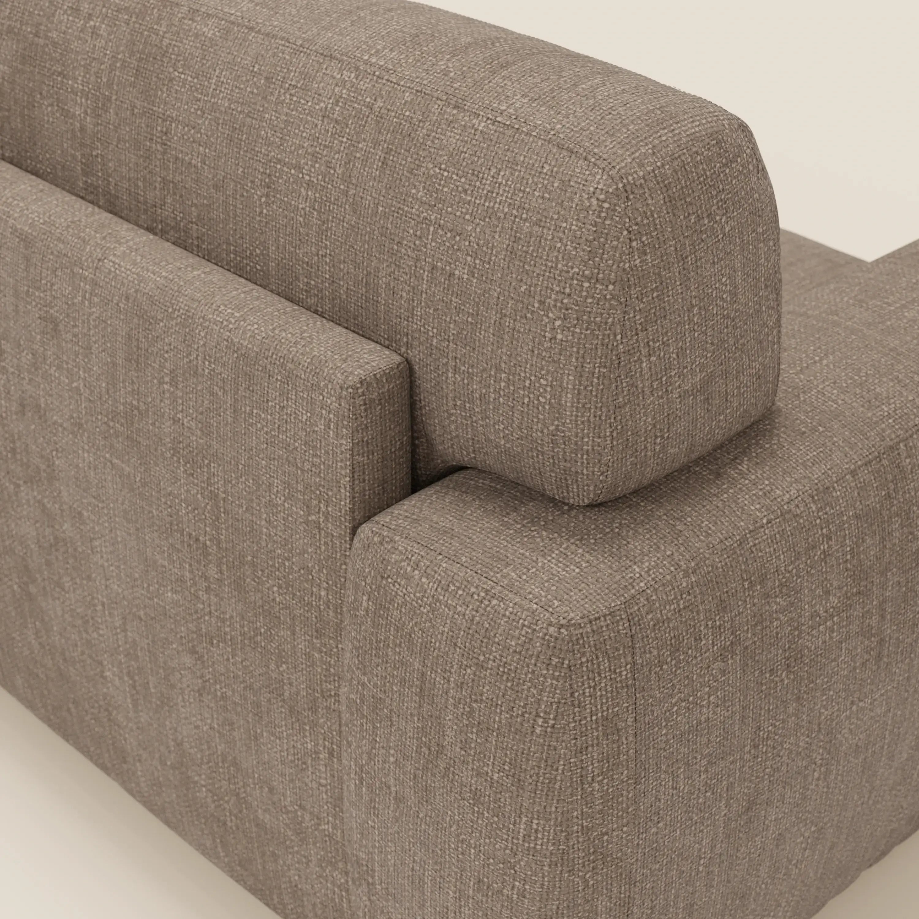 Un primo piano del letto materasso Cloud Divano H17 cm di Divani.Store in tessuto impermeabile T06 marrone, che mostra l'angolo in cui schienale e bracciolo si incontrano, mette in evidenza i cuscini morbidi e il sottile motivo intrecciato su uno sfondo chiaro.