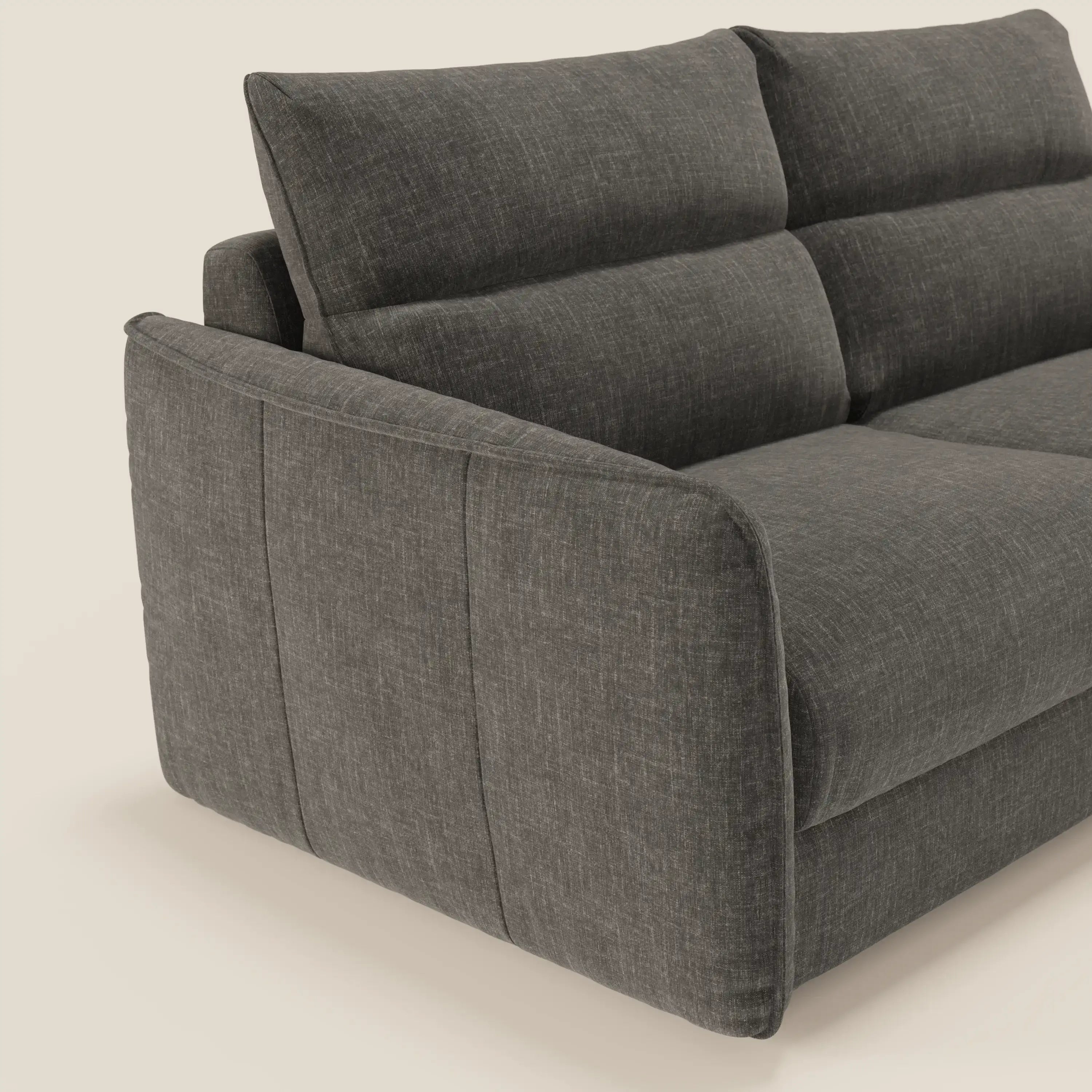 Un primo piano del divano letto Divani.Store Elios con cuscini morbidi spalliera in tessuto smacchiabile T24 antracite, caratterizzato da cuscini morbidi, linee pulite e un look contemporaneo su uno sfondo chiaro.