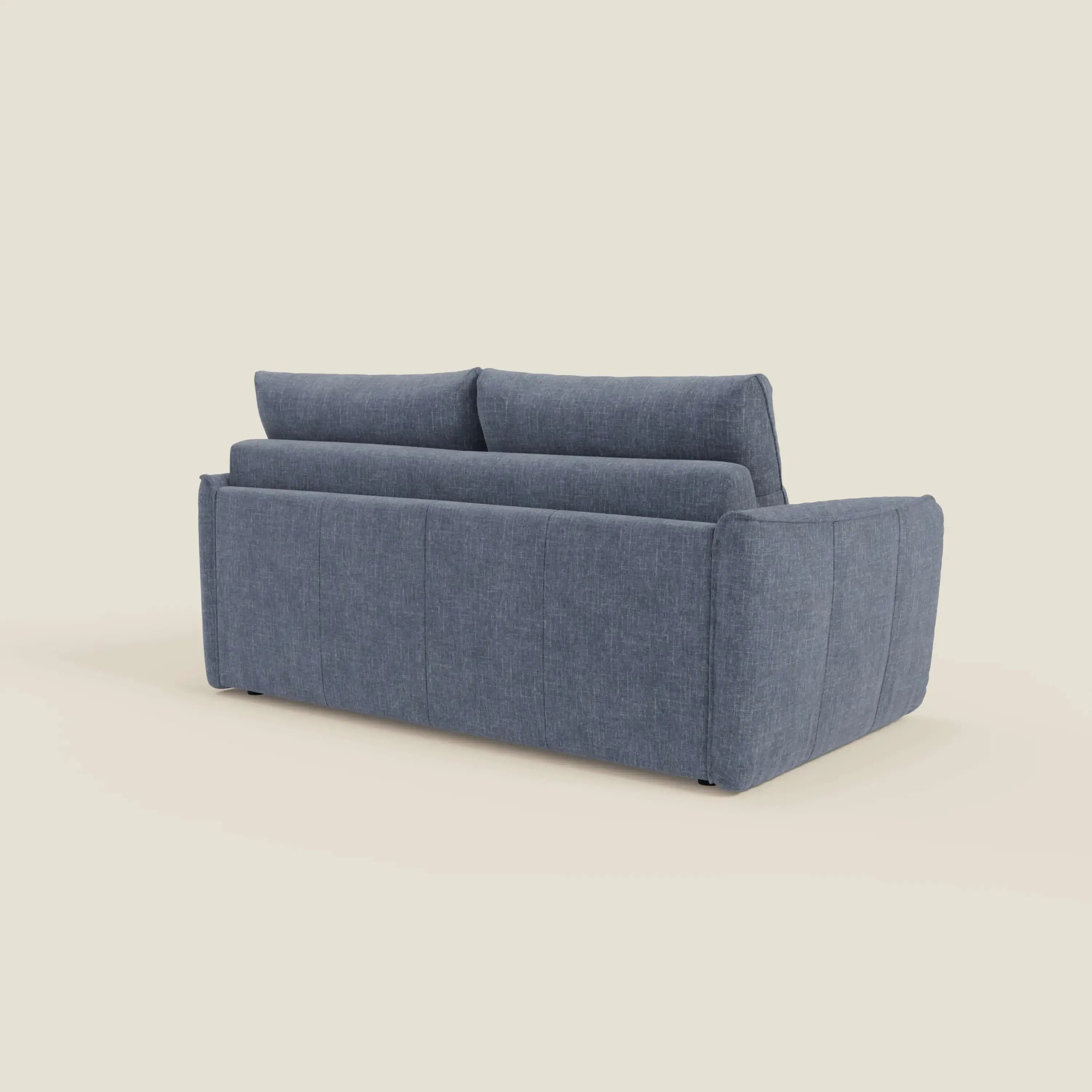 Elios Divano letto di Divani.Store, presentato dal retro su sfondo beige, è caratterizzato da morbidi cuscini spalliera in tessuto smacchiabile T24 blu ardesia, ampi braccioli e un design semplice e squadrato con sottili cuciture verticali.
