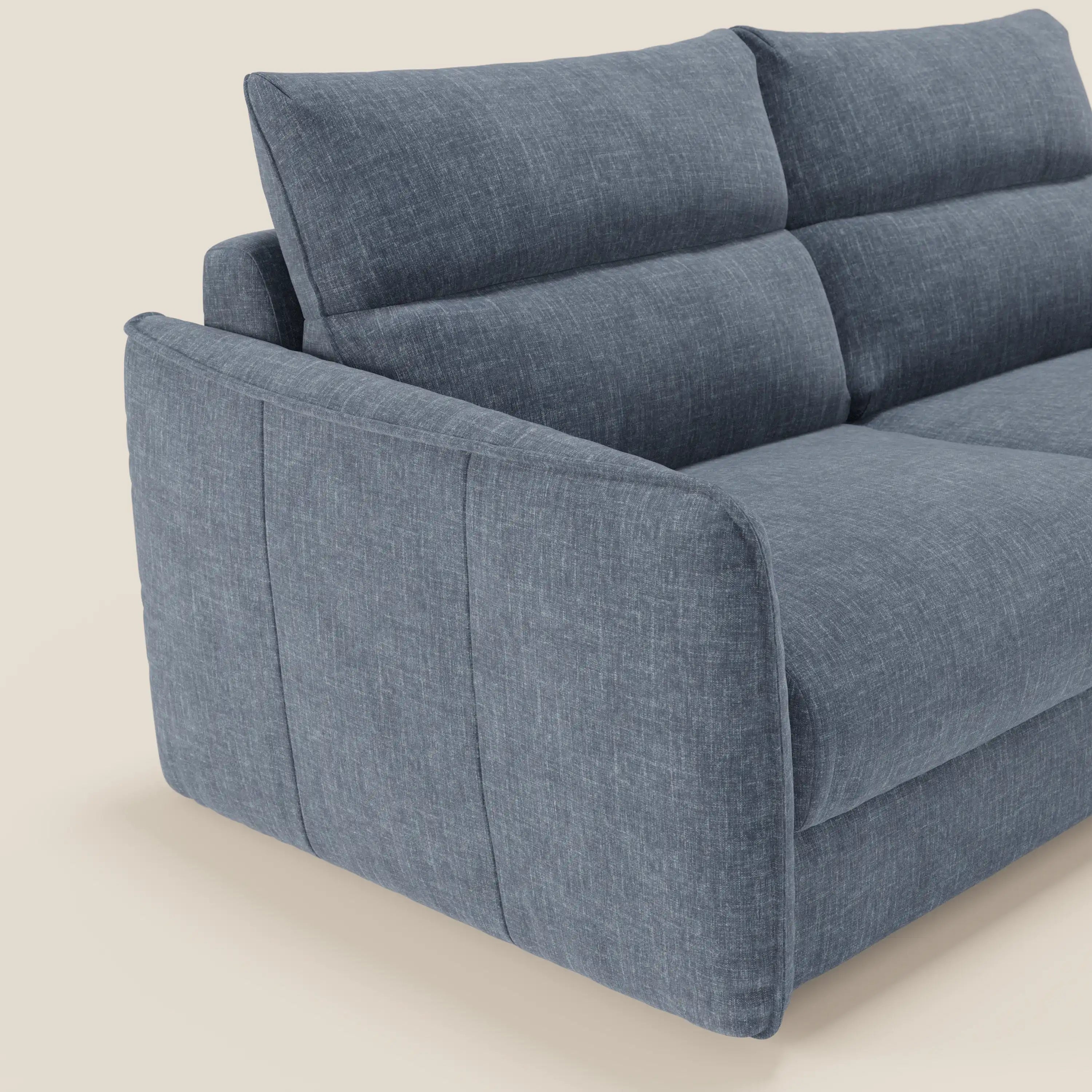 Una vista angolata e ravvicinata del Divani.Store Elios Divano letto con morbidi cuscini spalliera in tessuto smacchiabile T24 blu ardesia, caratterizzato da linee pulite e contemporanee, tessuto strutturato e braccioli imbottiti su uno sfondo chiaro.