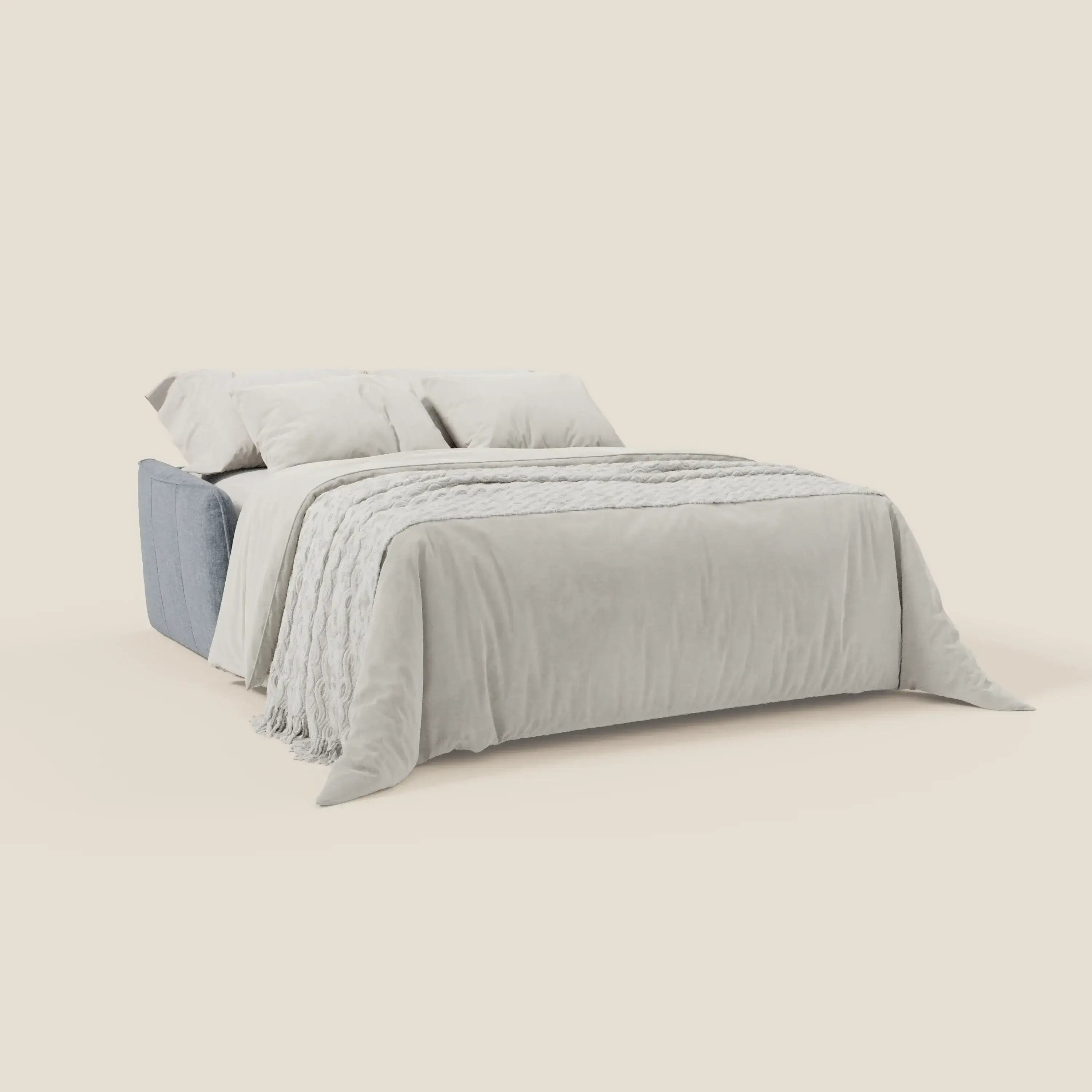 Un letto ben fatto è quello di Elios Divano letto di Divani.Store, con morbidi cuscini di schienale in tessuto T24 carta da zucchero, facile da pulire, e una struttura imbottita blu. La biancheria da letto è di colore grigio chiaro e lo sfondo è di un semplice bianco sporco.