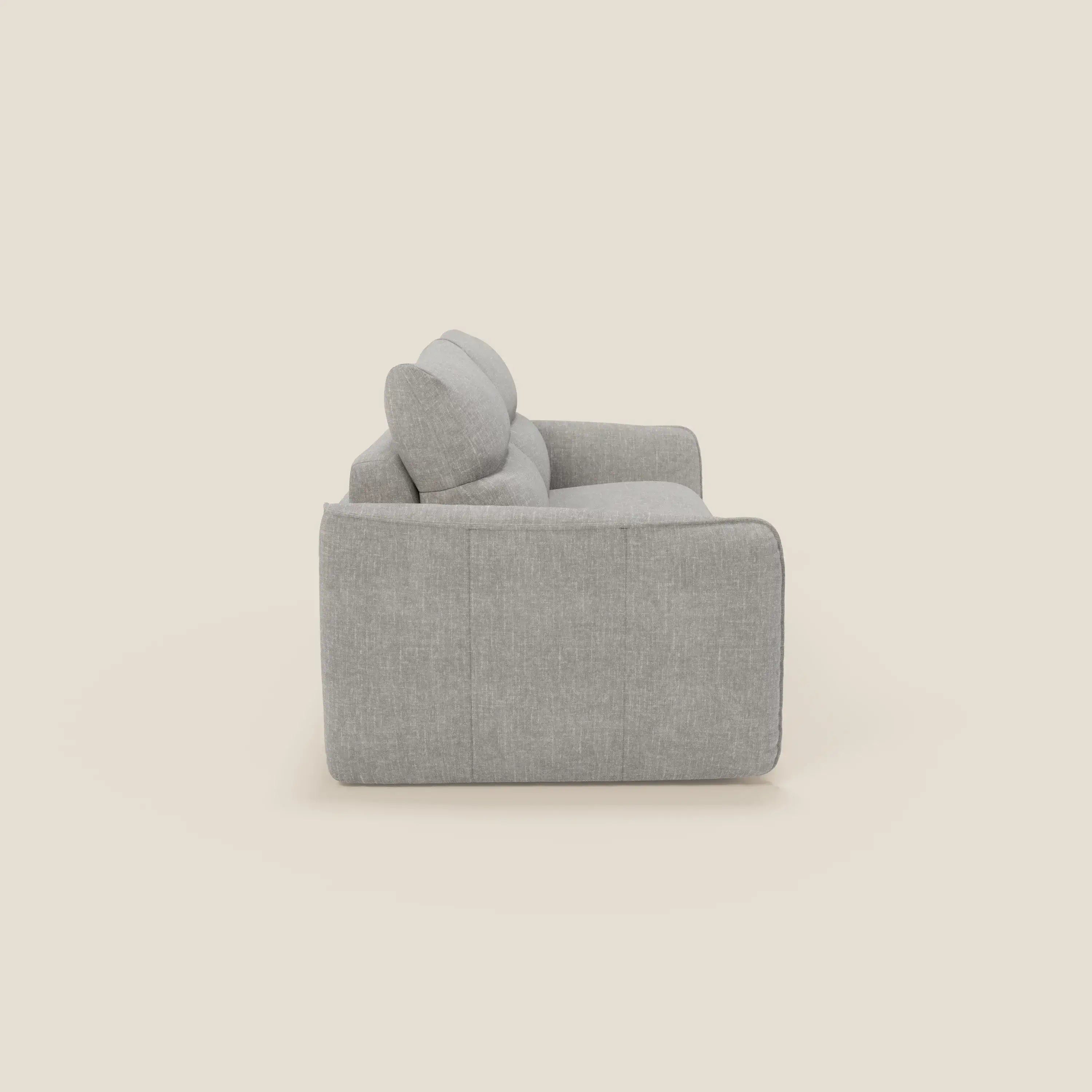 Vista laterale del divano letto Elios con morbidi cuscini spalliera in tessuto smacchiabile T24 grigio di Divani.Store, caratterizzato da spessi cuscini e da un design squadrato e moderno in grigio chiaro su sfondo bianco sporco.