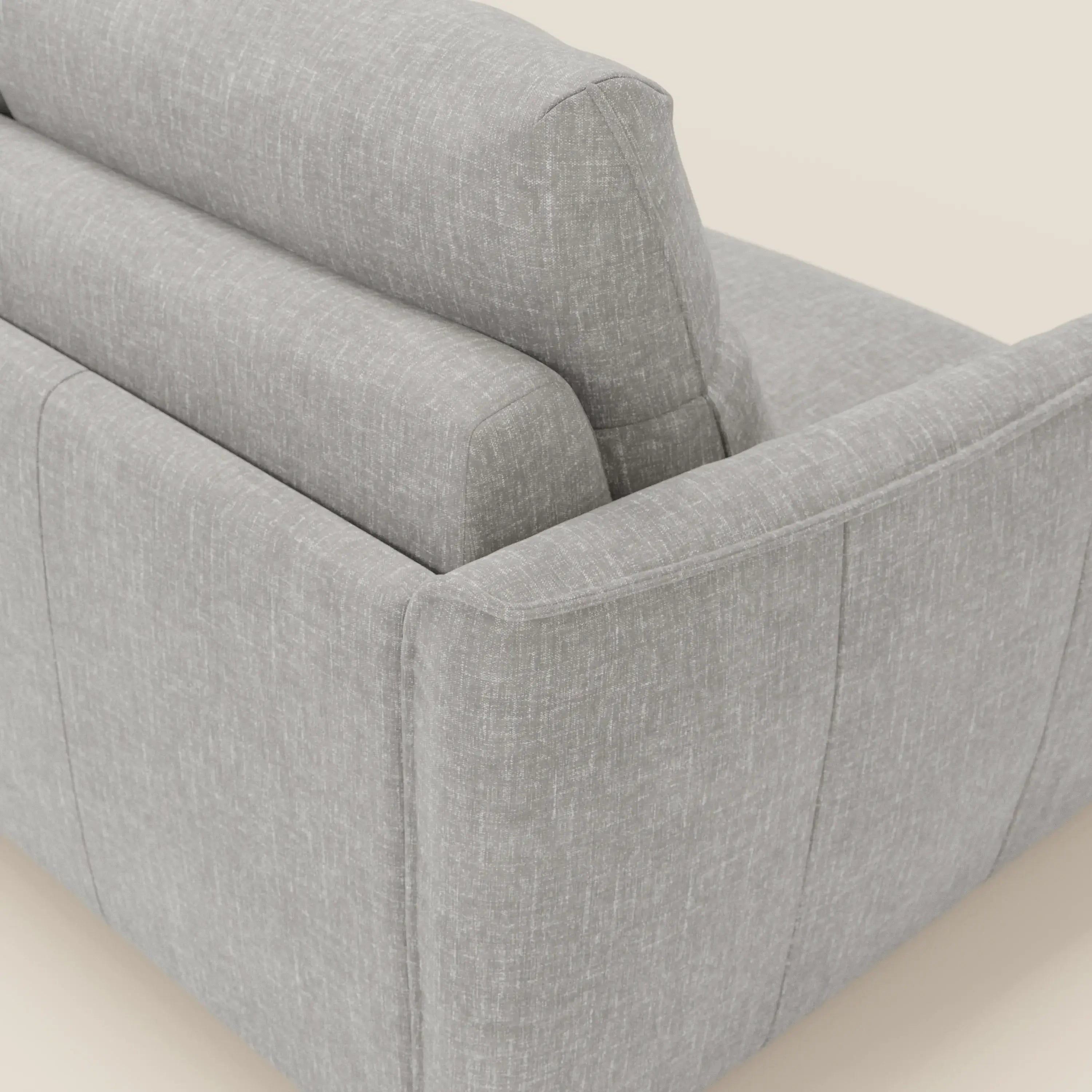 Una vista ravvicinata e angolata del divano letto Elios con morbidi cuscini spalliera in tessuto smacchiabile T24 grigio di Divani.Store, che mette in evidenza il bracciolo imbottito, lo schienale, i cuscini di seduta e le linee contemporanee per un comfort moderno.