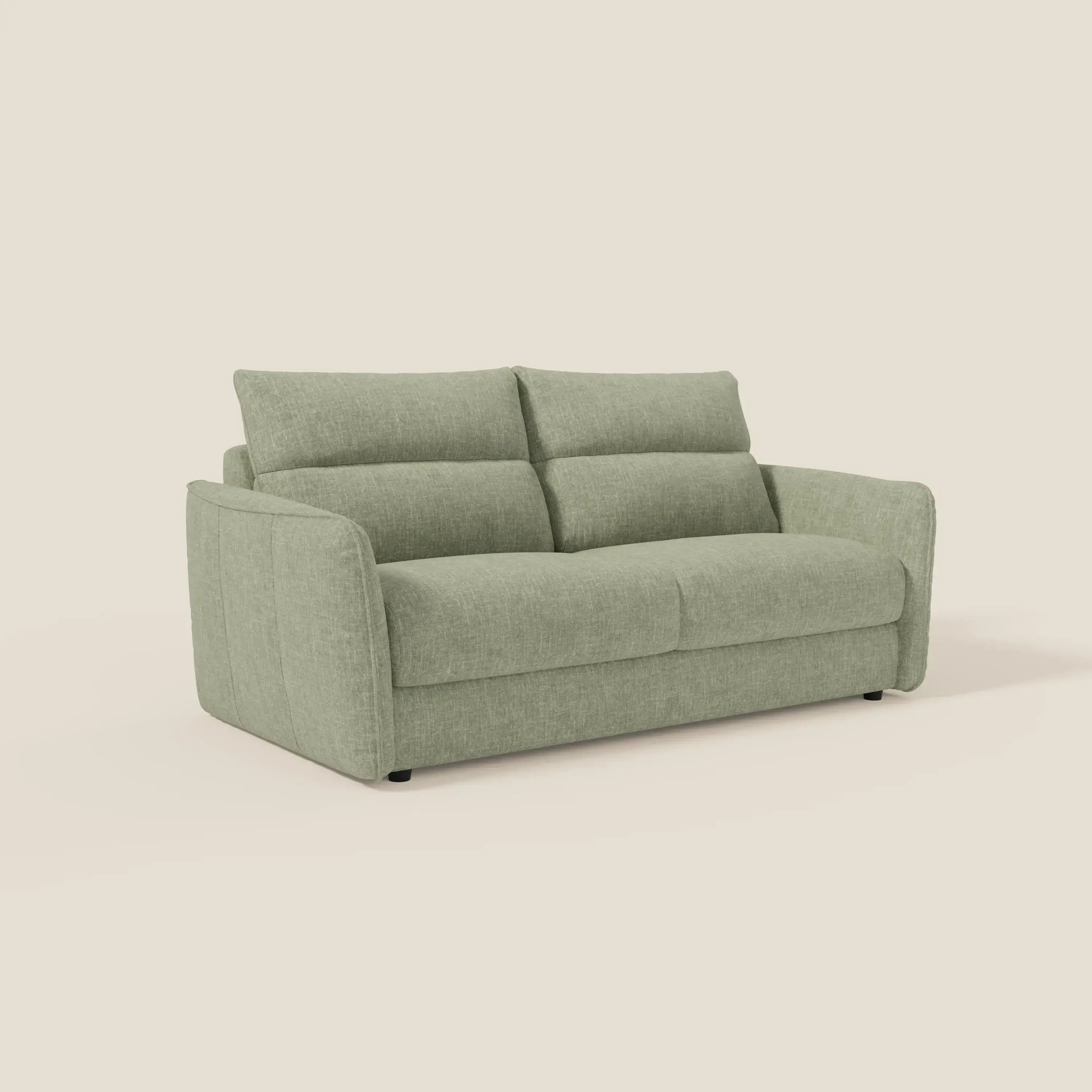 Il divano letto Elios di Divani.Store, in tessuto smacchiabile T24 verde salvia con spalliera di cuscini morbidi, ampi braccioli rettangolari e discrete gambe nere, si colloca su uno sfondo bianco sporco per un look moderno ed elegante.