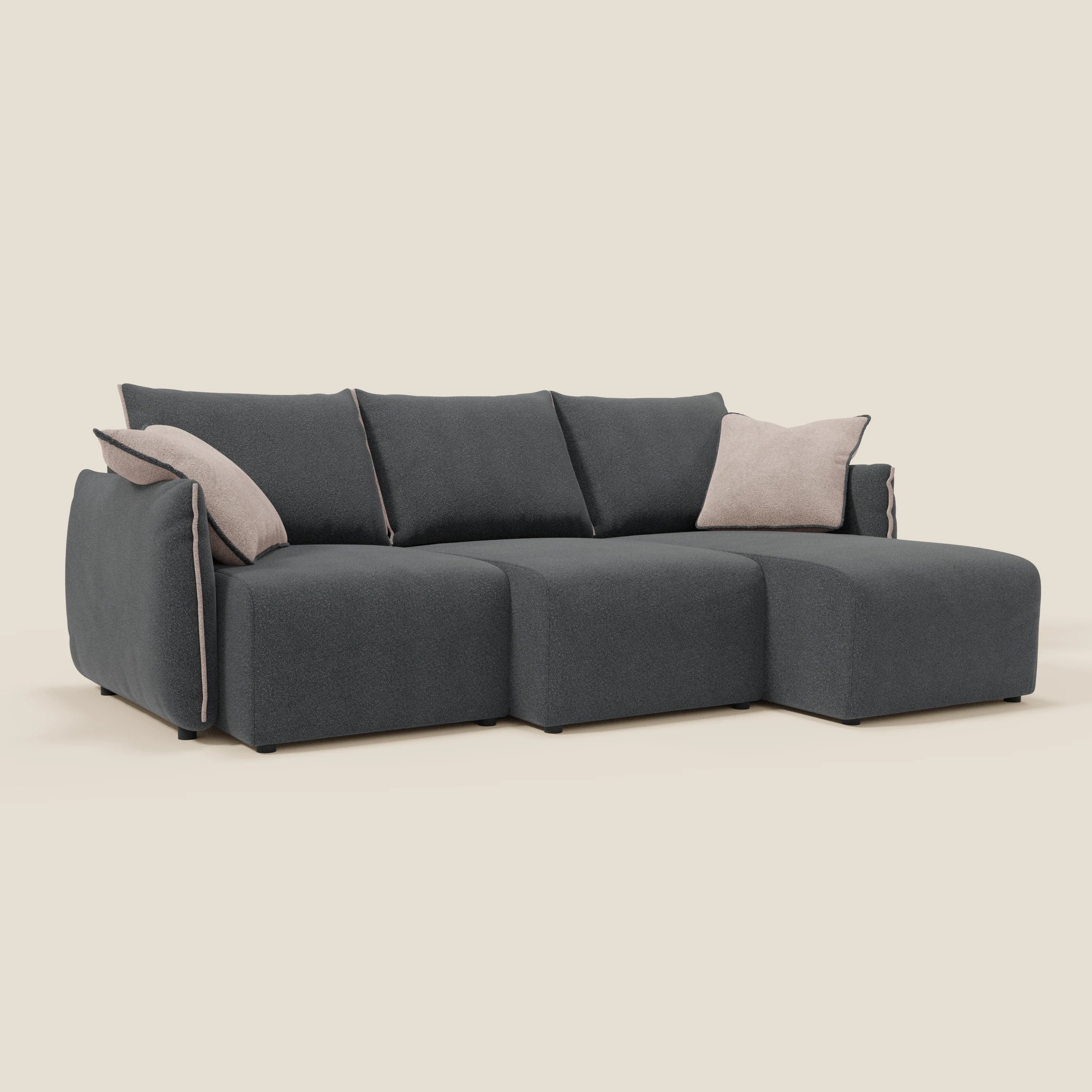 Flexar Divano angolare reversibile di Divani.Store è caratterizzato da tre sezioni di seduta in bouclé impermeabile T07 antracite-rosa, cuscini di schienale sciolti, due cuscini d'accento beige chiaro a sinistra e gambe basse nere su sfondo bianco sporco.