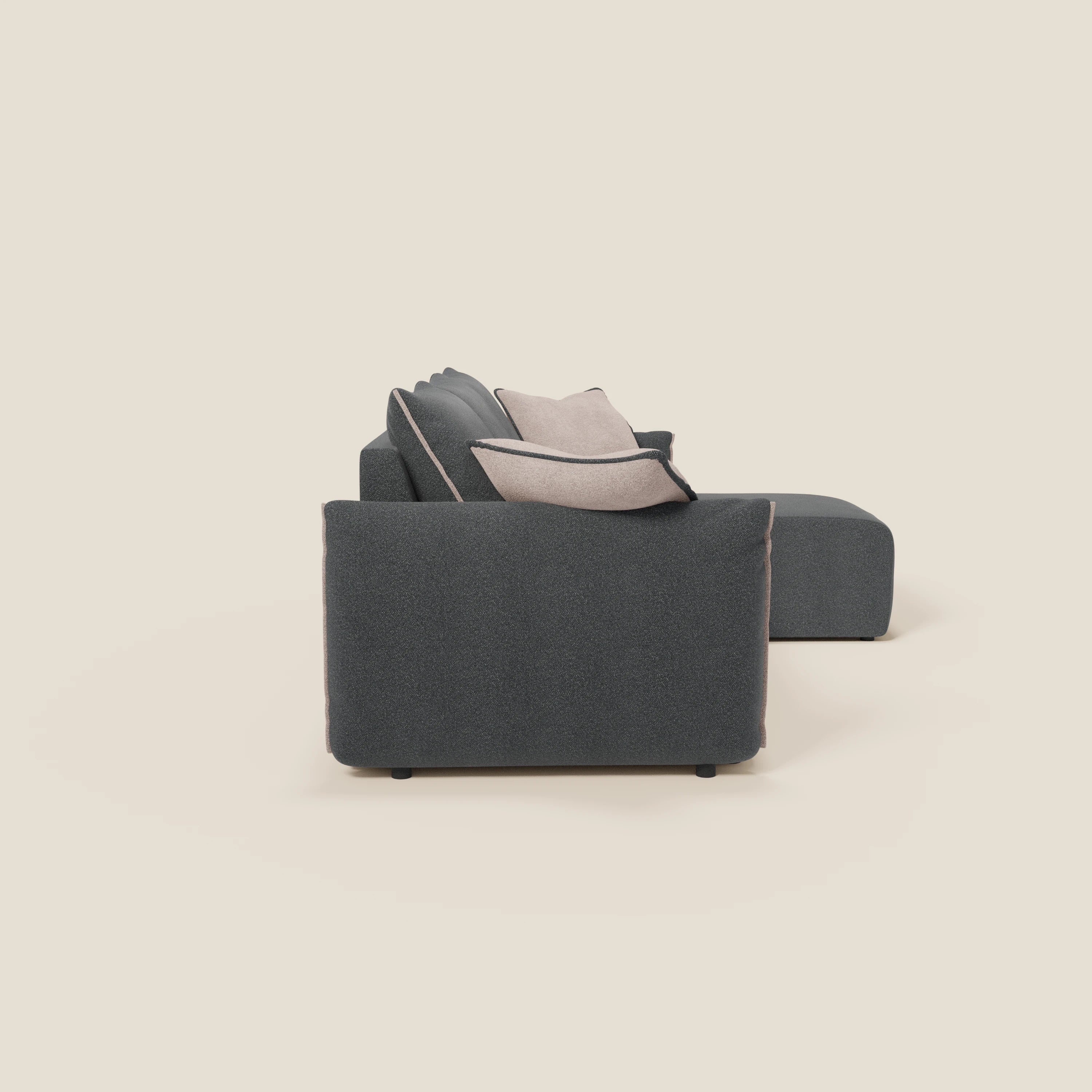Il Flexar Divano angolare reversibile di Divani.Store, in impermeabile bouclé T07 antracite-rosa con sedute allungate, è caratterizzato da una texture morbida e da un comfort modulabile, rappresentato lateralmente con cuscini beige chiaro su sfondo tinta unita.