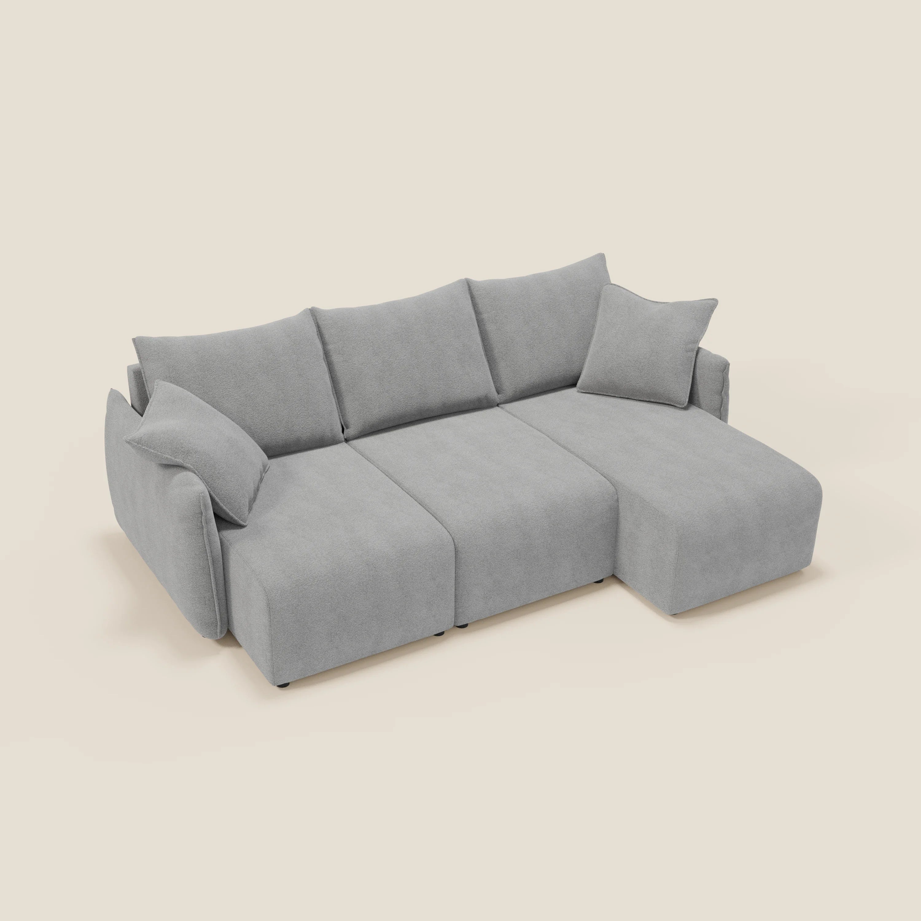 Il Flexar Divano angolare reversibile di Divani.Store, in morbido bouclé impermeabile T07 grigio chiaro, è caratterizzato da sedute allungabili, tre schienali, due braccioli, una chaise lounge destra e due cuscini coordinati su uno sfondo bianco sporco.
