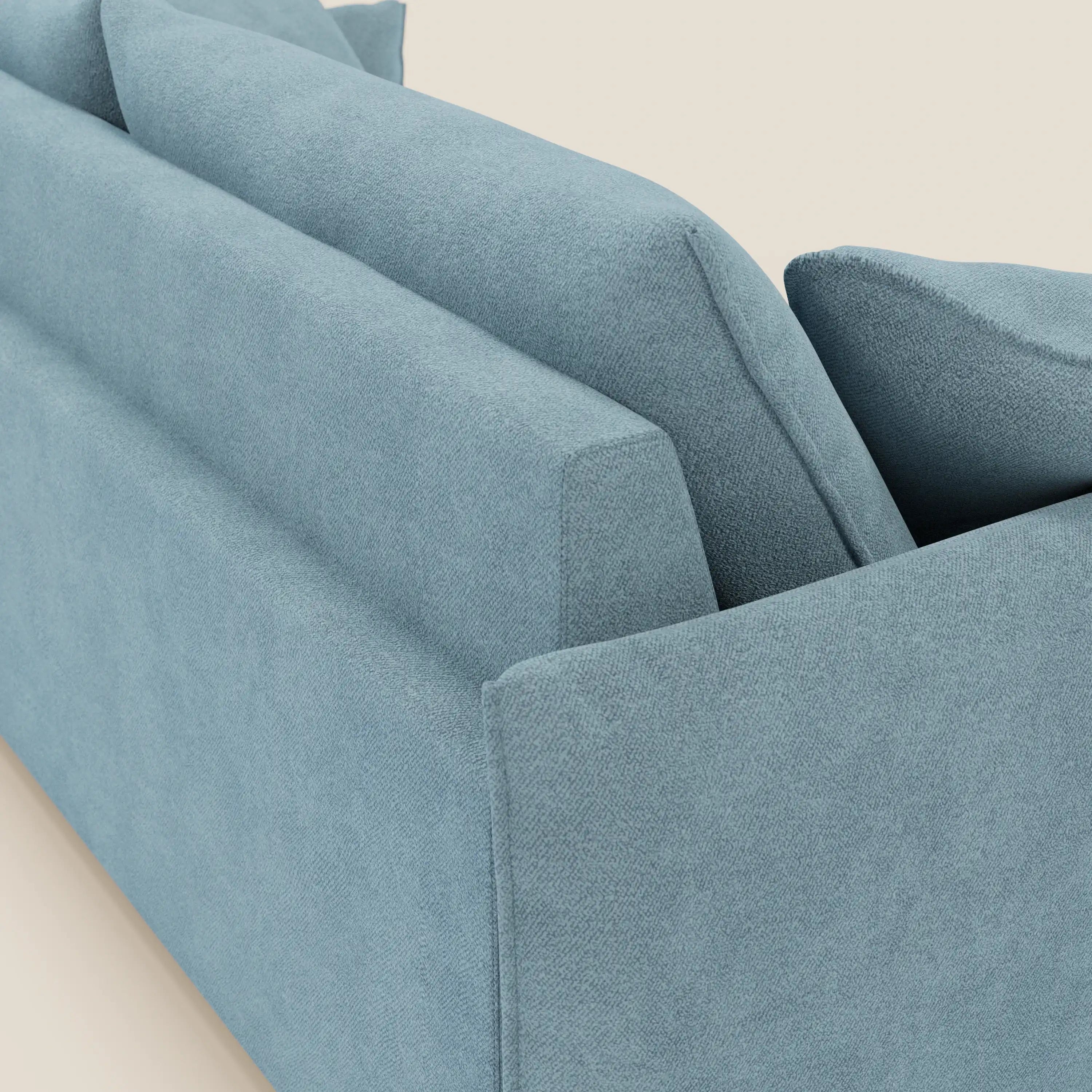 Una vista dettagliata del divano Flexar con sedute allungabili e schienale in piuma, in morbido bouclé impermeabile T07 carta da zucchero di Divani.Store, mette in evidenza le sue linee spigolose e gli ampi cuscini dello schienale su uno sfondo beige semplice.