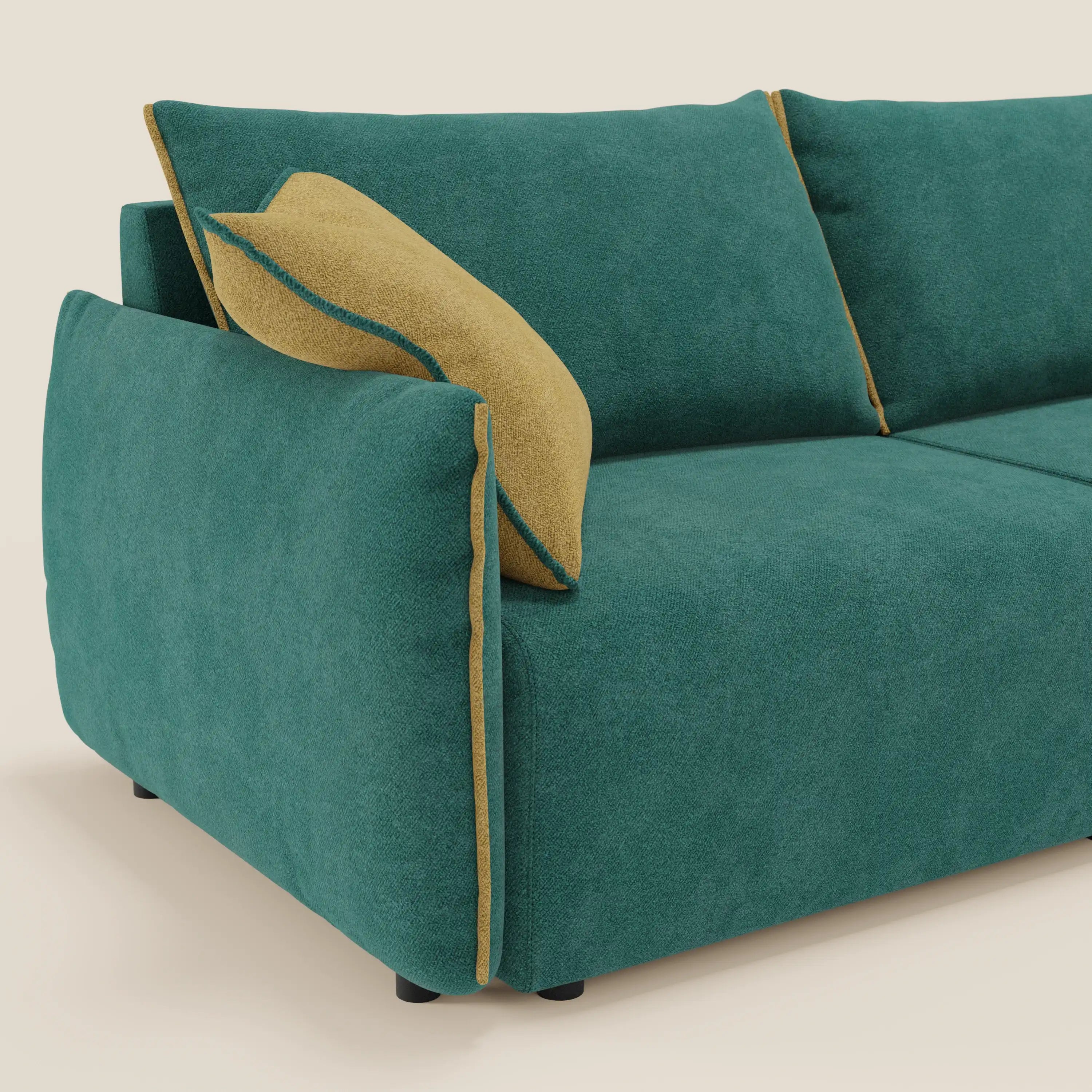 Il divano Flexar di Divani.Store, in morbido bouclé impermeabile T07 verde-giallo, è caratterizzato da sedute allungabili, schienale in piuma, linee pulite, cuscini in tessuto, gambe corte nere e cuscino giallo senape con profili verde acqua sul bracciolo sinistro.