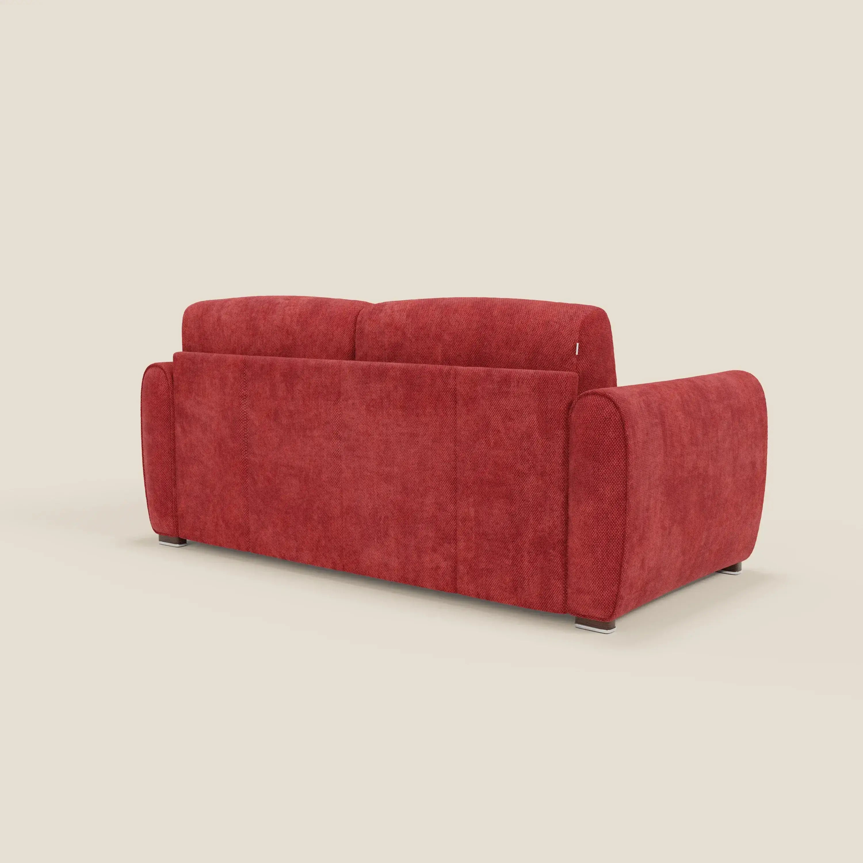 Il divano letto moderno Kaleo di Divani.Store, visto dal retro su uno sfondo beige chiaro, è caratterizzato da un vivace rivestimento in tessuto impermeabile rosso T26, braccioli curvi, schienale alto e gambe corte scure.