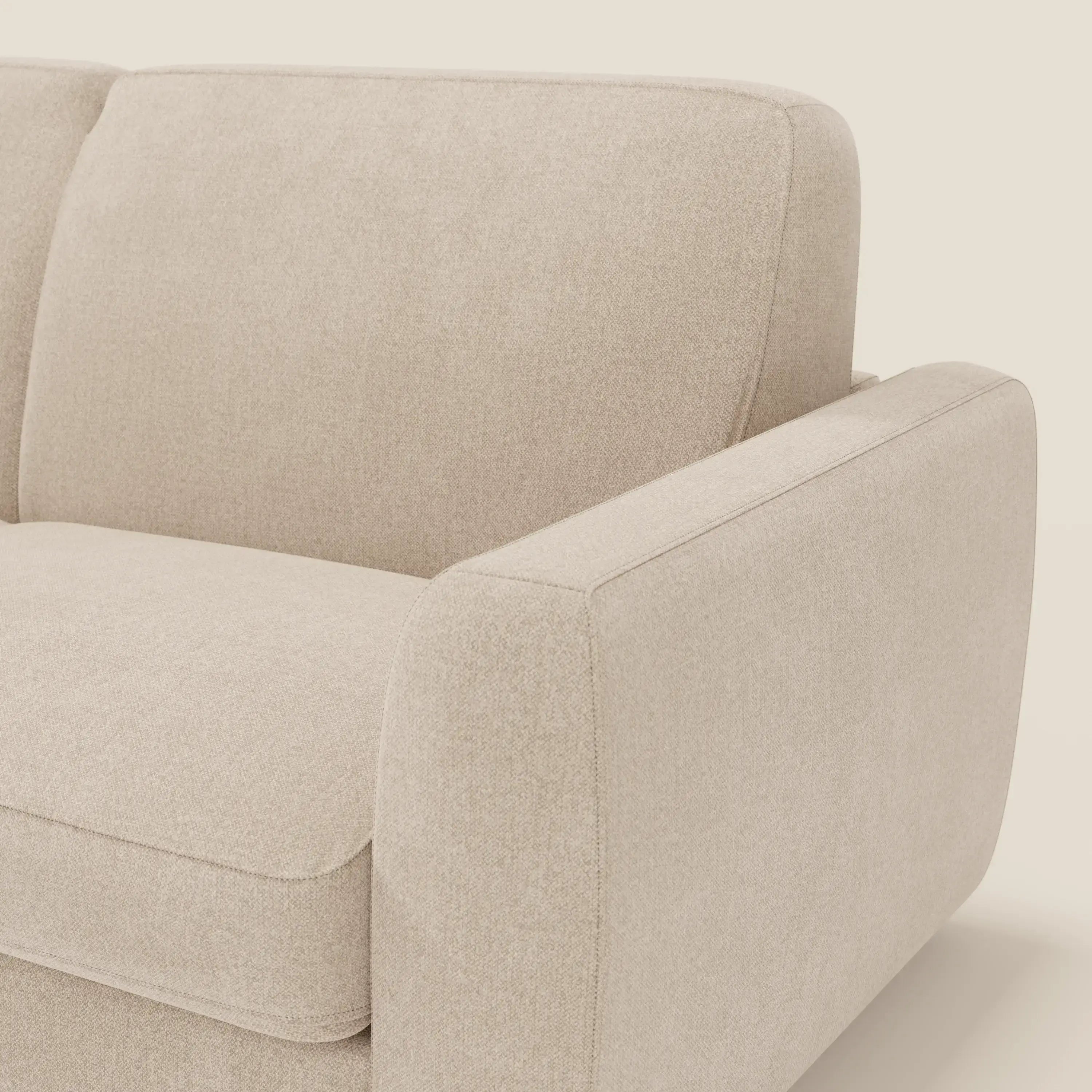 Primo piano del divano letto sfoderabile Divani.Store Leonida in tessuto Smacchiabile T23 beige, con cuscini in tessuto, bracciolo ampio e arrotondato e materasso H18 cm per il massimo comfort, su sfondo bianco.